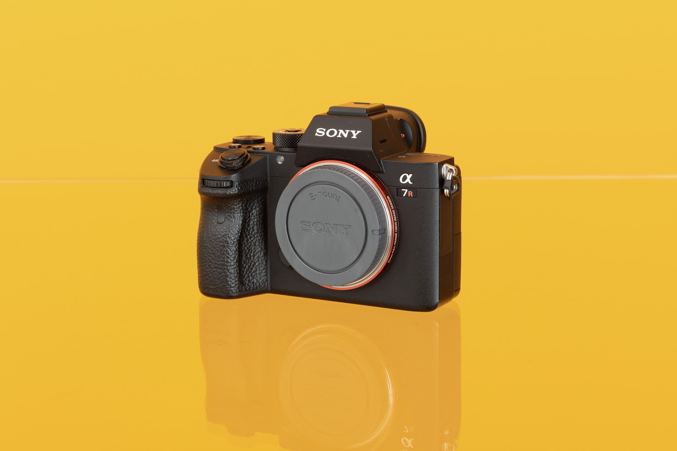 A photo of a Sony A7R III full-frame mirrorless camera against a yellow background