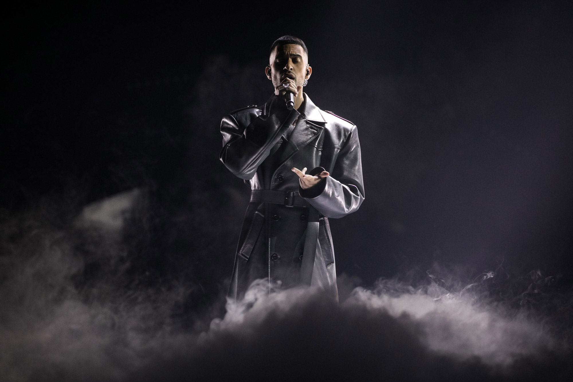 A performer on stage at Eurovision with smoke coming up to their waist.
