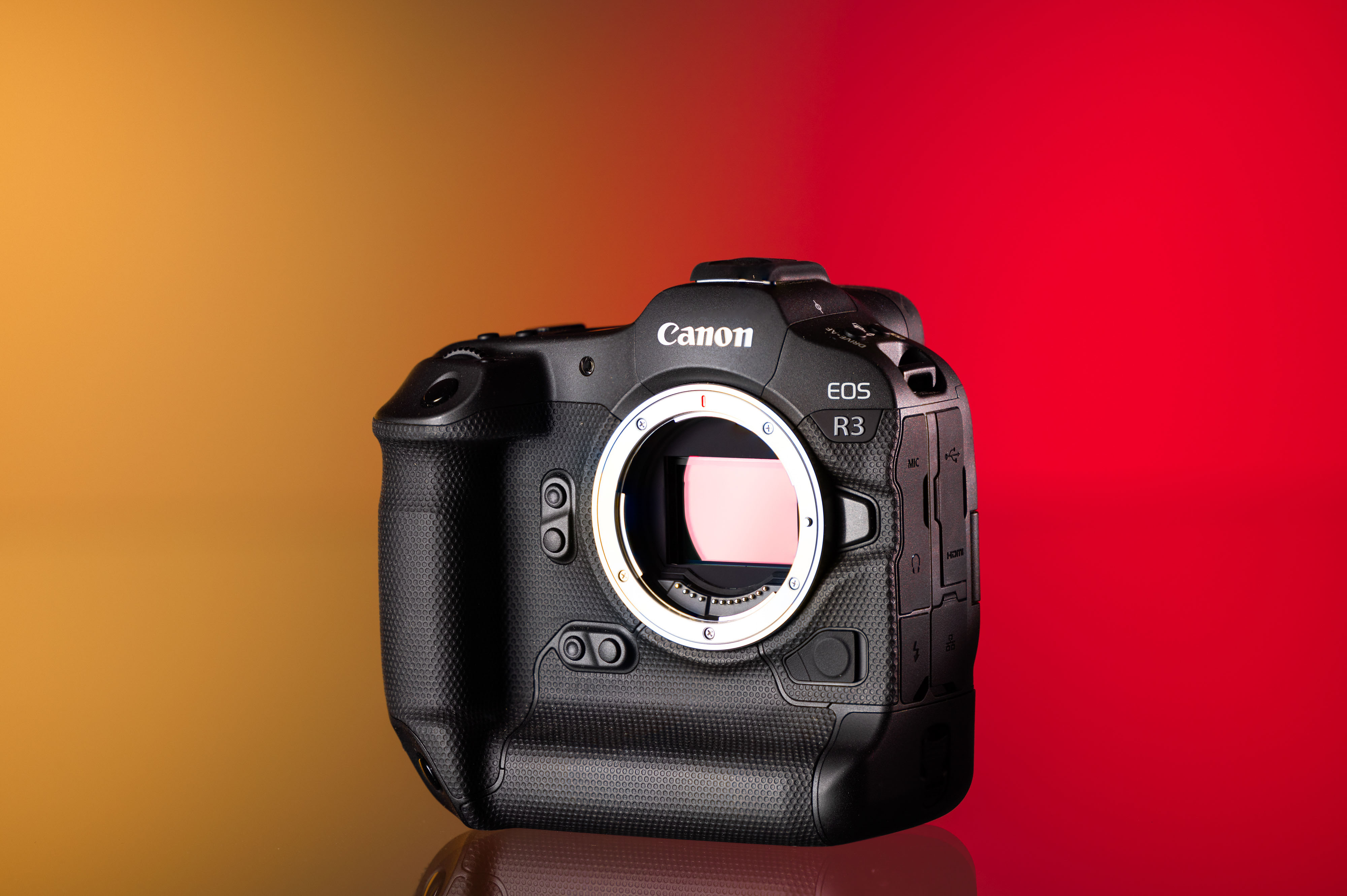 Cámara Canon EOS R3 de segunda mano sobre un fondo amarillo y rojo