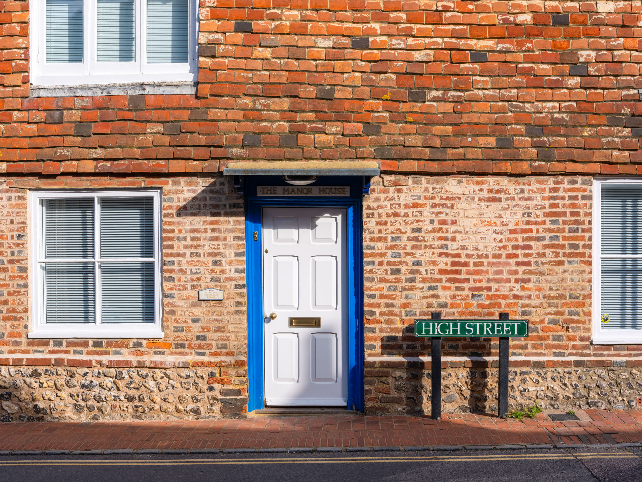 The front of a house showing a door, three windows and a street sign that reads ‘High Street’