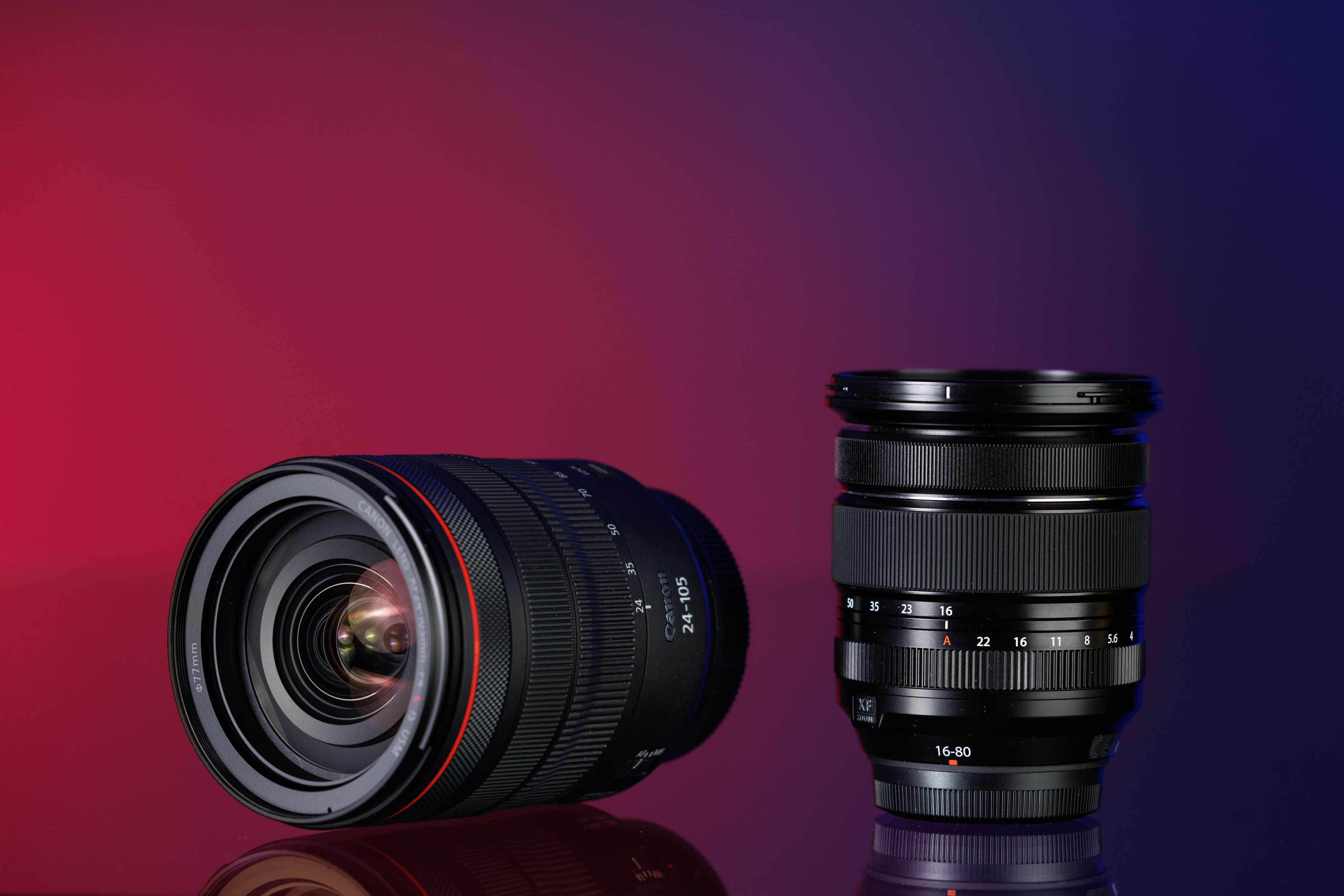 Tweedehands Canon RF 24105 f/4 L IS USM en Fujifilm XF 1680mm f/4 R OIS WR op een blauwe en rode achtergrond
