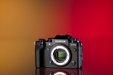 Cámara Fujifilm X-T4 de segunda mano sobre un fondo amarillo y rojo