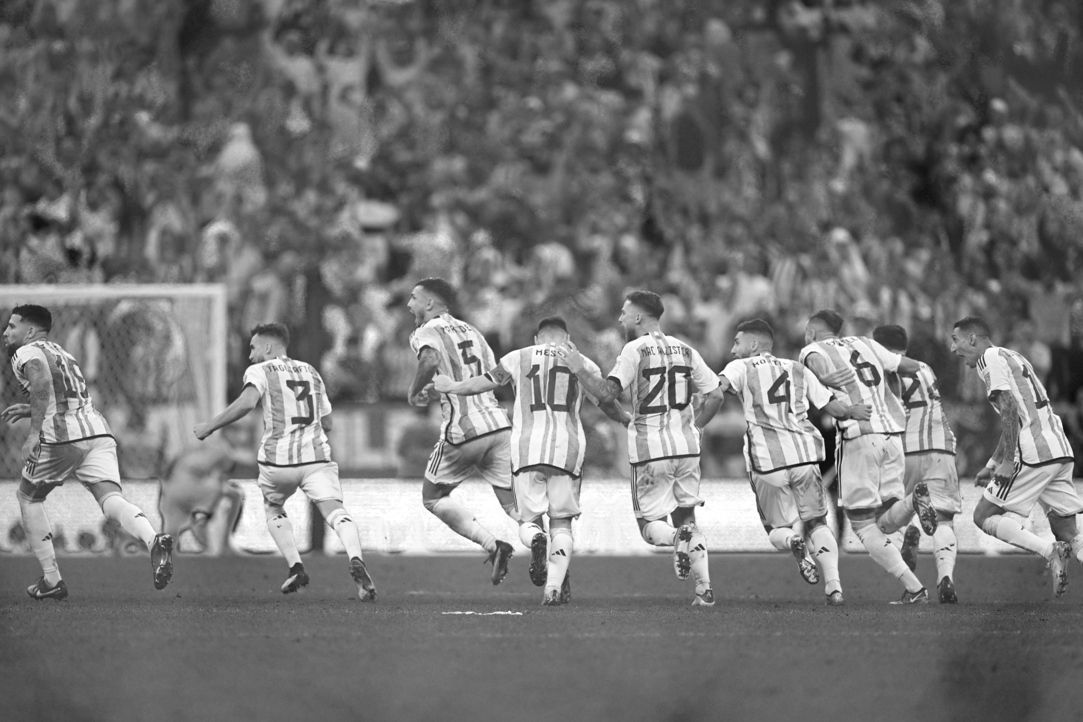 Ein Schwarz-Weiß-Foto der argentinischen Mannschaft, die ihren Sieg im Elfmeterschießen gegen die Niederlande im Viertelfinale der Fußball-Weltmeisterschaft 2022 feiert, aufgenommen von Ryu Voelkel mit einer Nikon Z9.