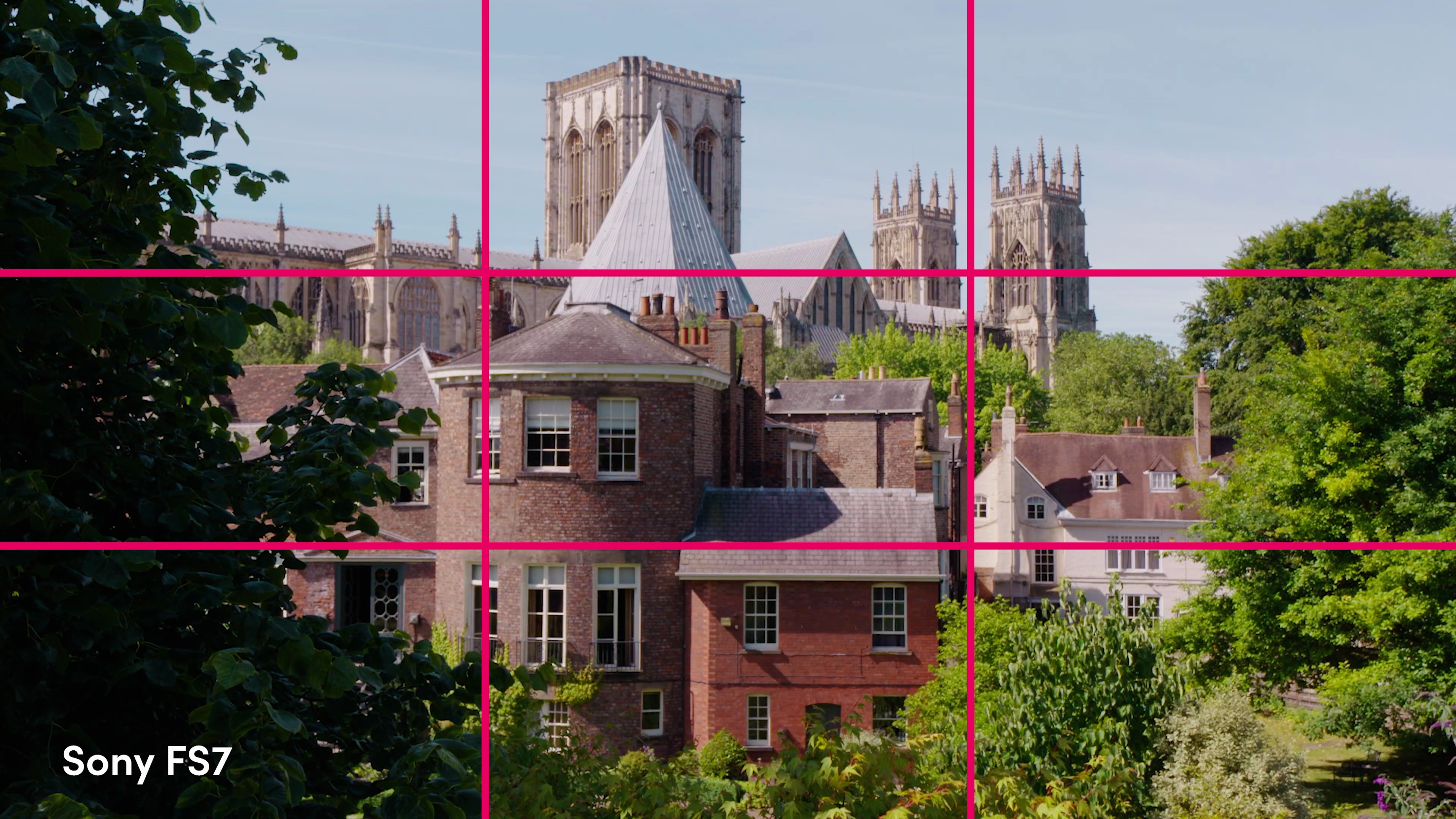 Photo de la cathédrale de York avec des bâtiments en briques devant elle, avec une grille rose vif superposée indiquant l'utilisation de la règle des tiers.