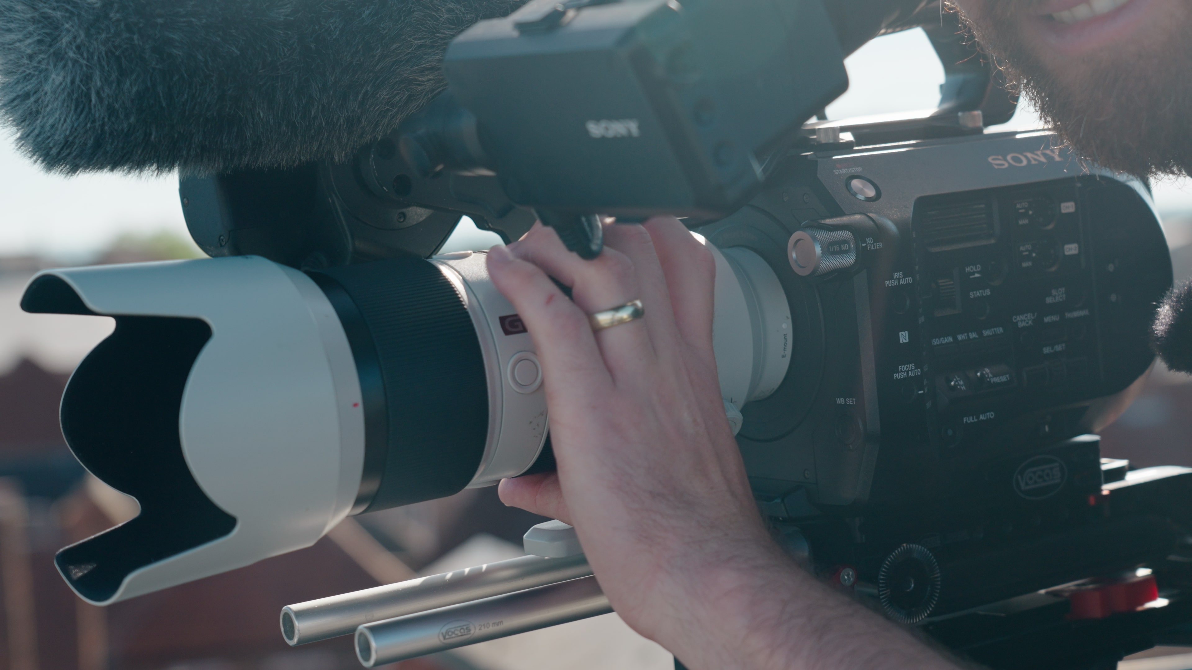 La main du producteur-réalisateur Steve Morgan actionne un objectif Sony blanc monté sur un Sony FS7.
