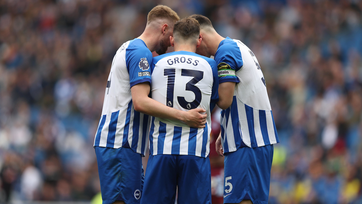 Drie voetbalspelers met de koppen bij elkaar op het veld