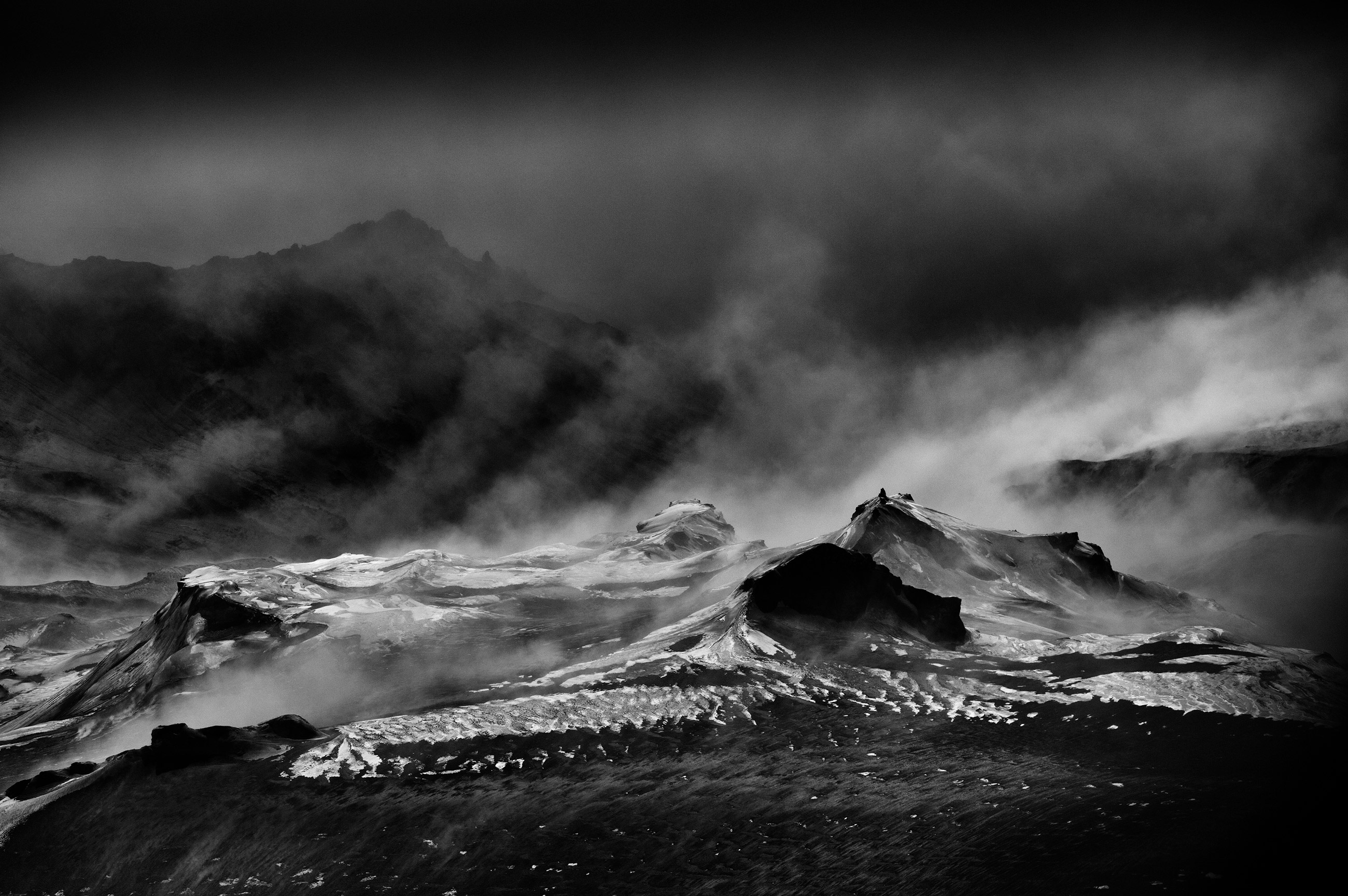 Stimmungsvolle Schwarz-Weiß-Aufnahme einer eisigen Berglandschaft mit Nebel, Foto aufgenommen von Ragnar Axelsson