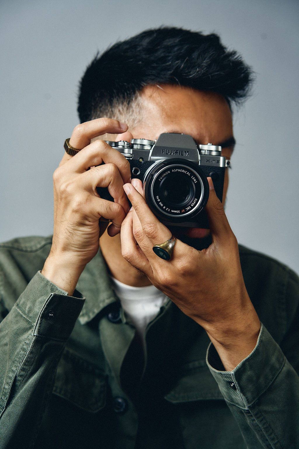 A photographer looking through the viewfinder of their Fujifilm camera