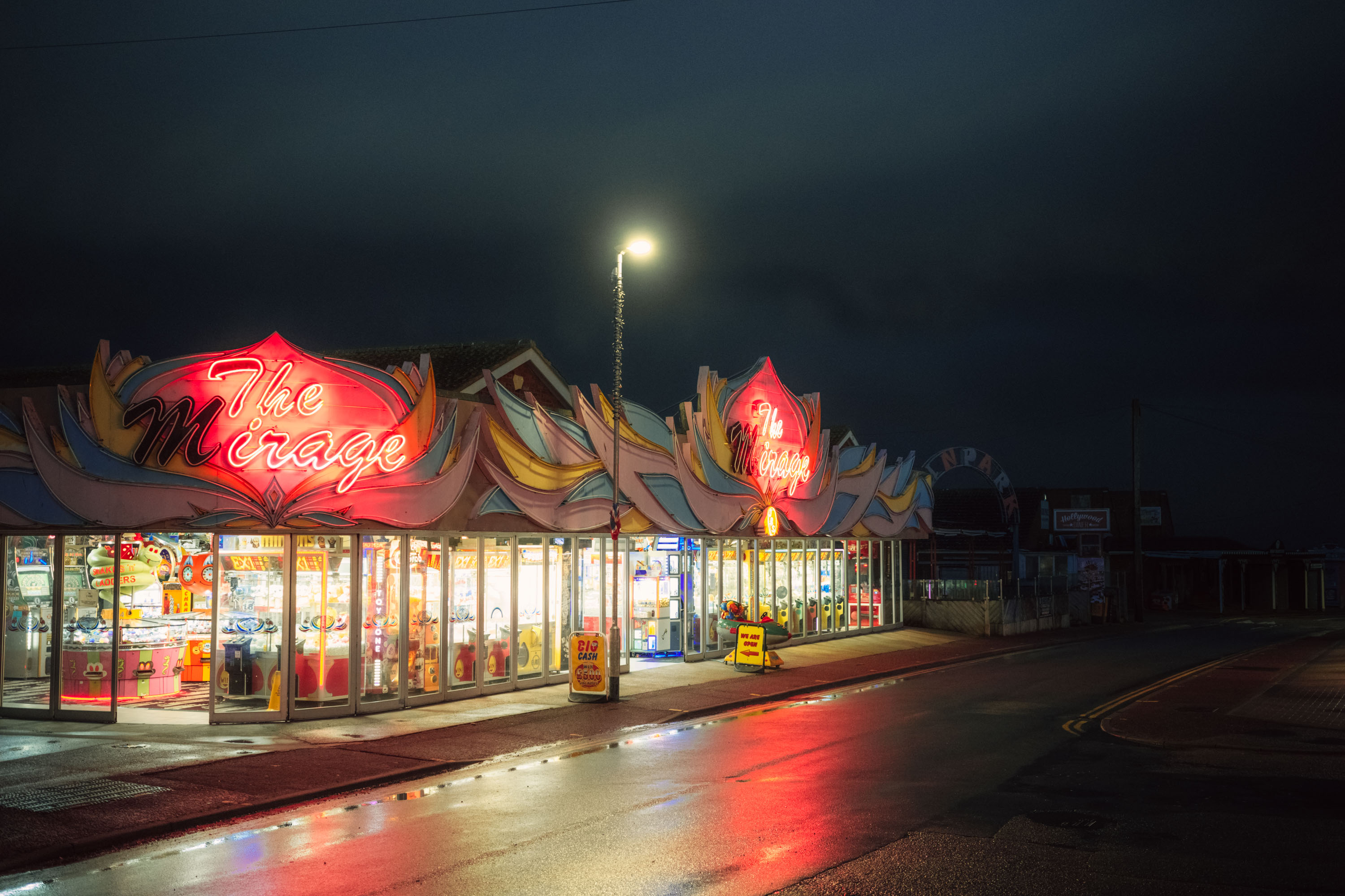 
 La “salle de jeux” ‘ The Mirage’, photographiée de nuit avec les enseignes au néon seulement à moitié éclairées. Par Ian Howorth.

