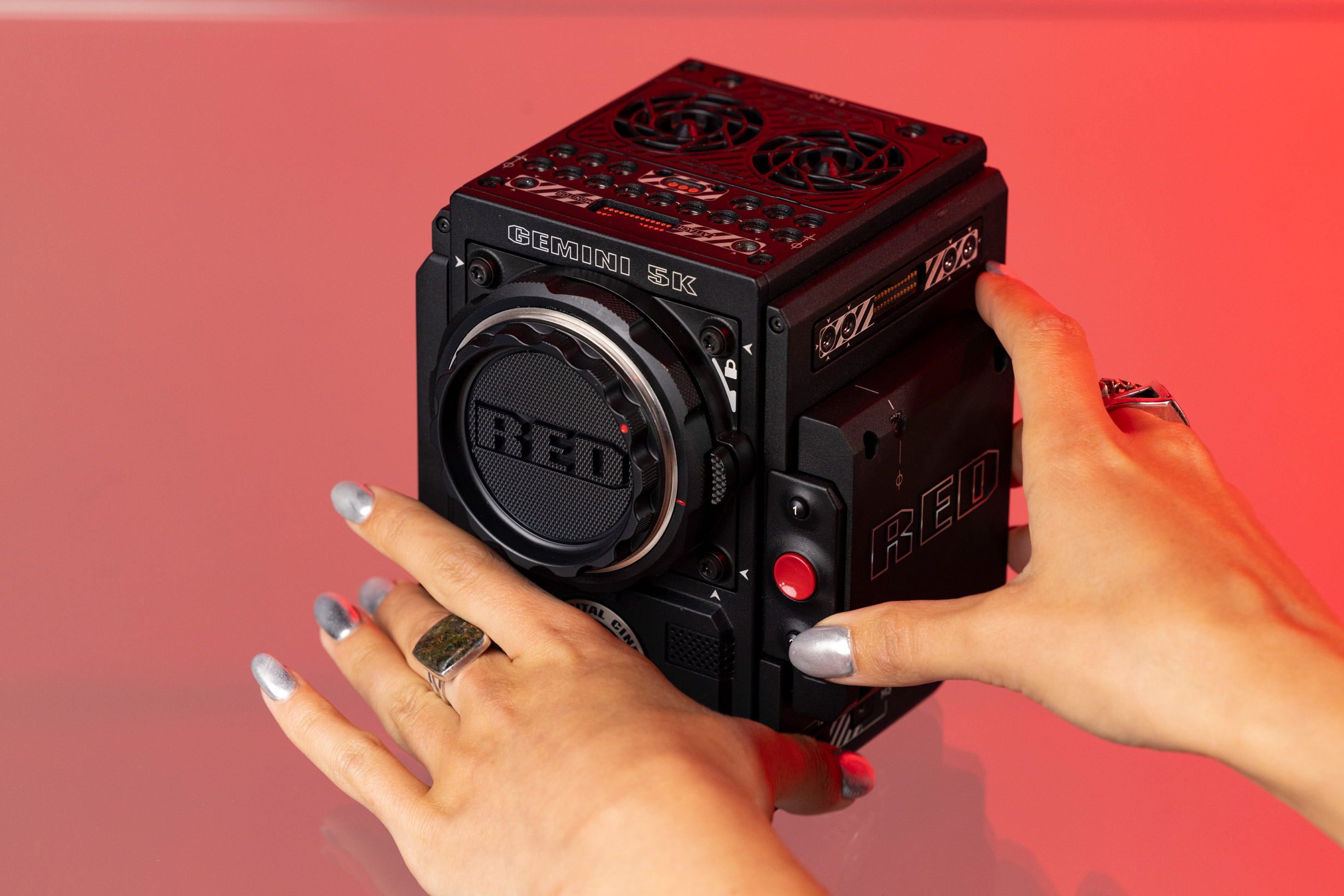 Hands holding RED Gemini 5k on a pink background