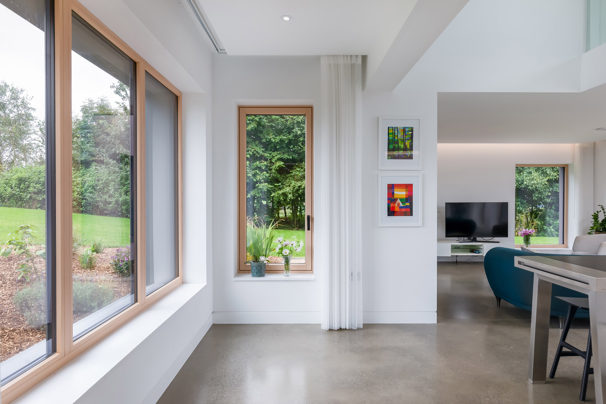 De binnenkant van een huis, met een tuin zichtbaar door twee ramen, gefotografeerd door Paul Moore met de Canon EOS 5D Mark IV.