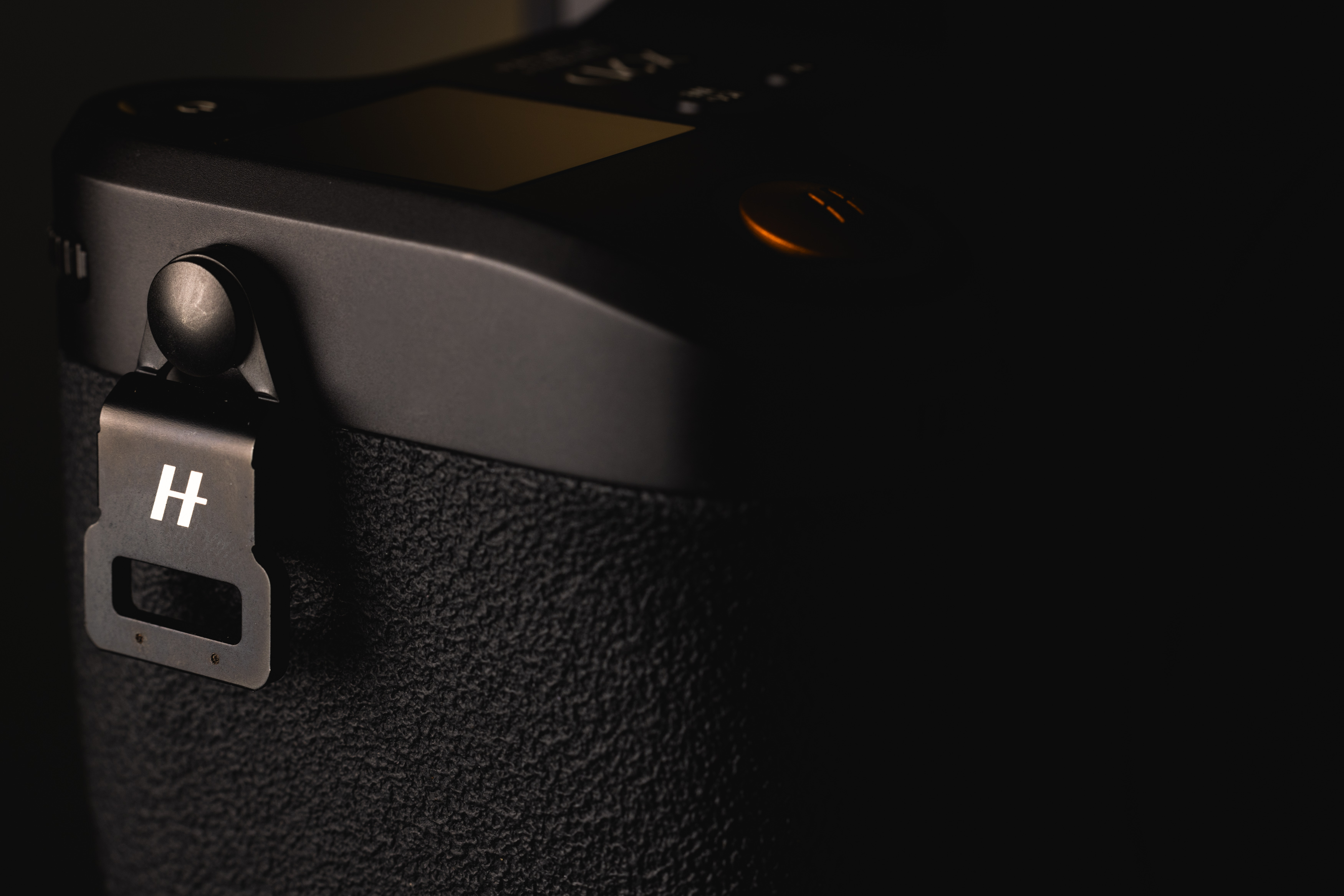 Close-up van een Hasselblad X2D 100C met focus op de nekbandbevestiging