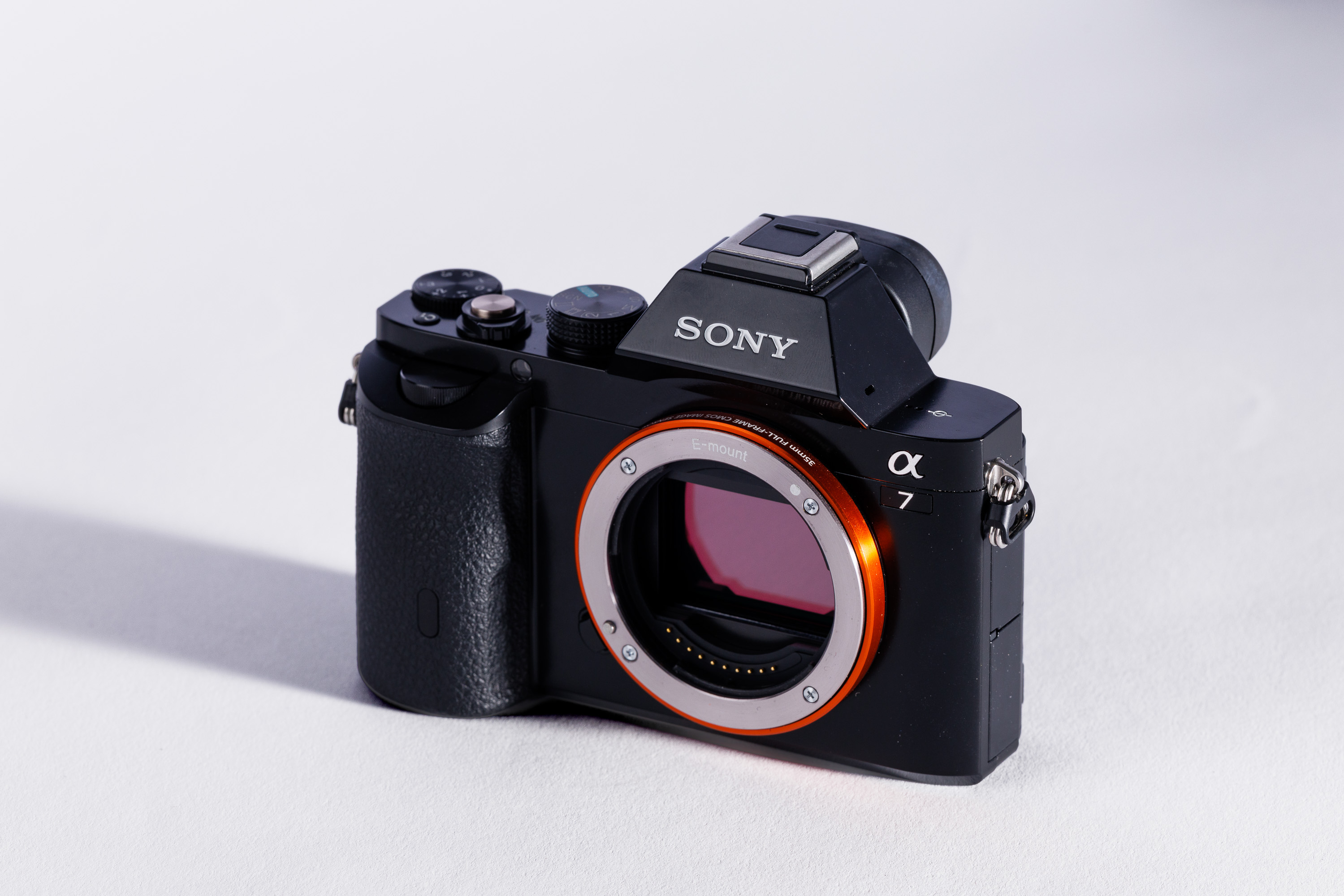 A used Sony A7 body on a white background, with a shadow to the left. 