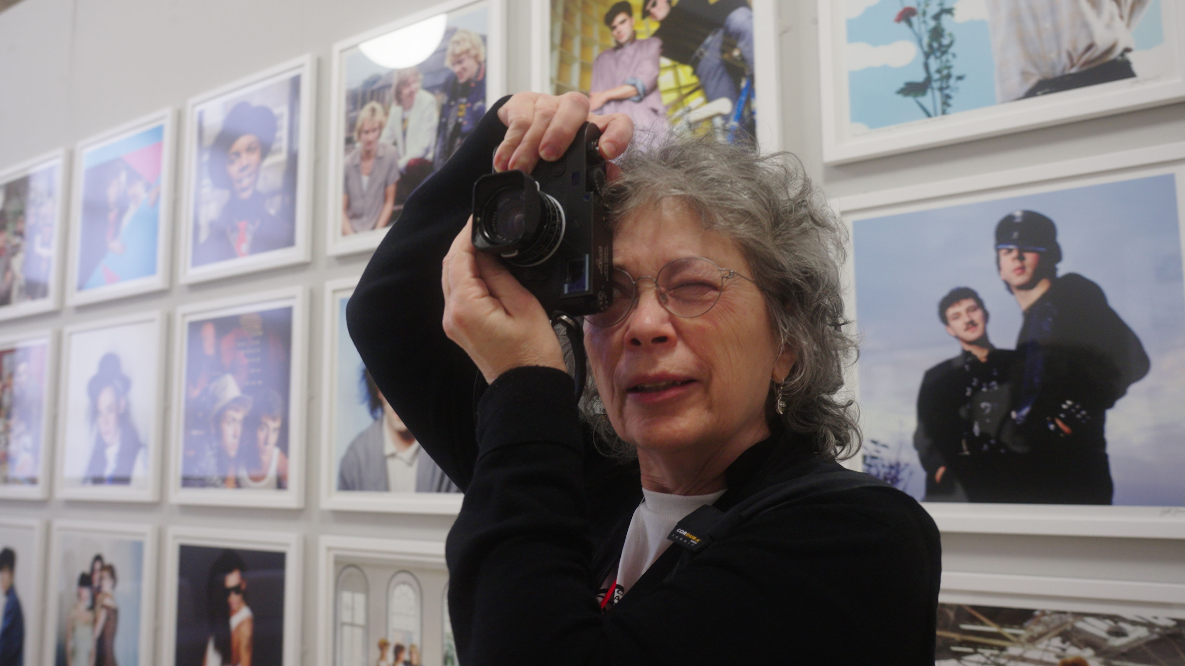 A photo of the iconic music photographer Jill Furmanovsky using a camera