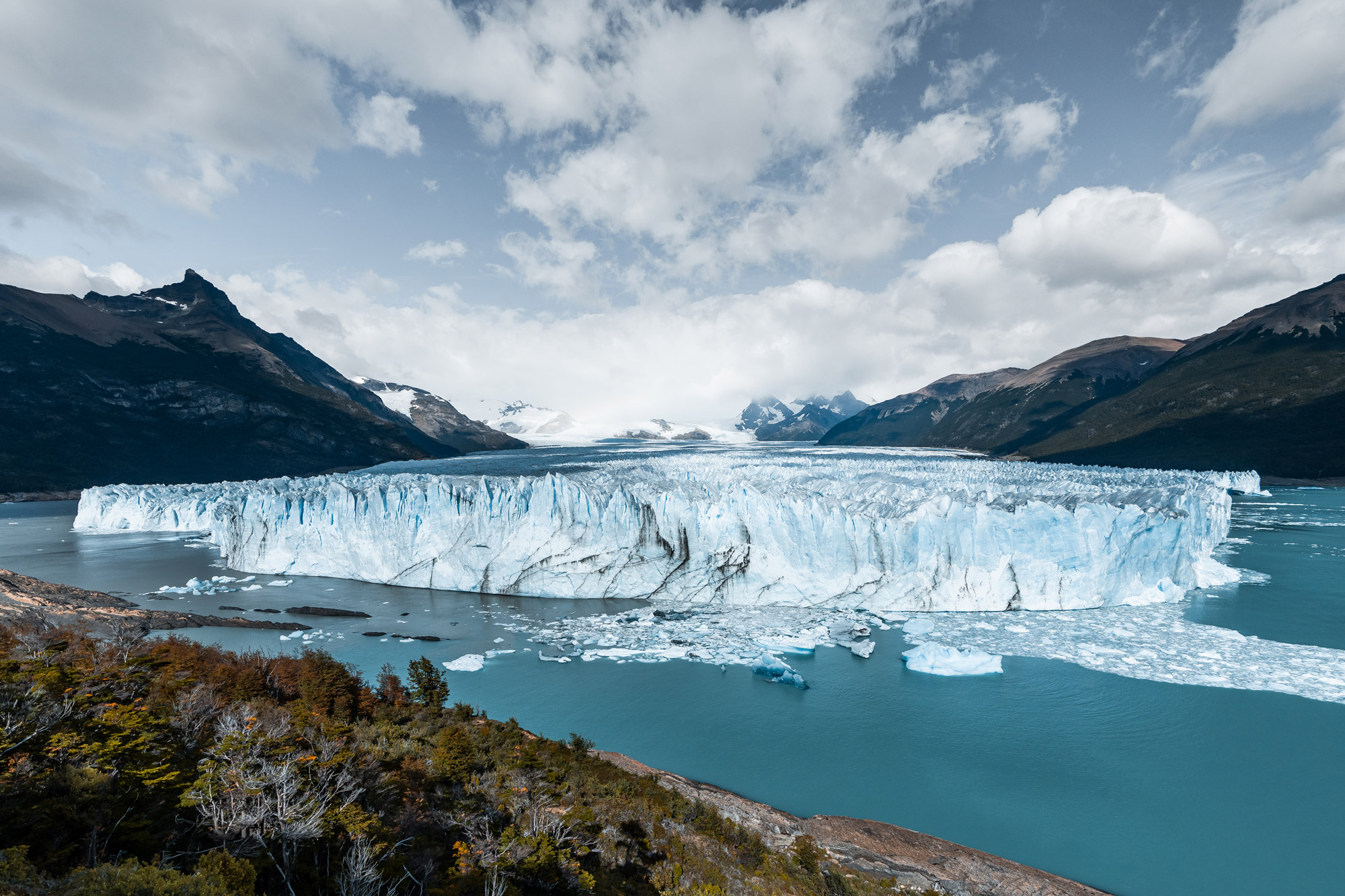 Glacier in a glacial lake with mountain landscape behind, photographed by Marvin Kuhr with the Sony A7 IV.
