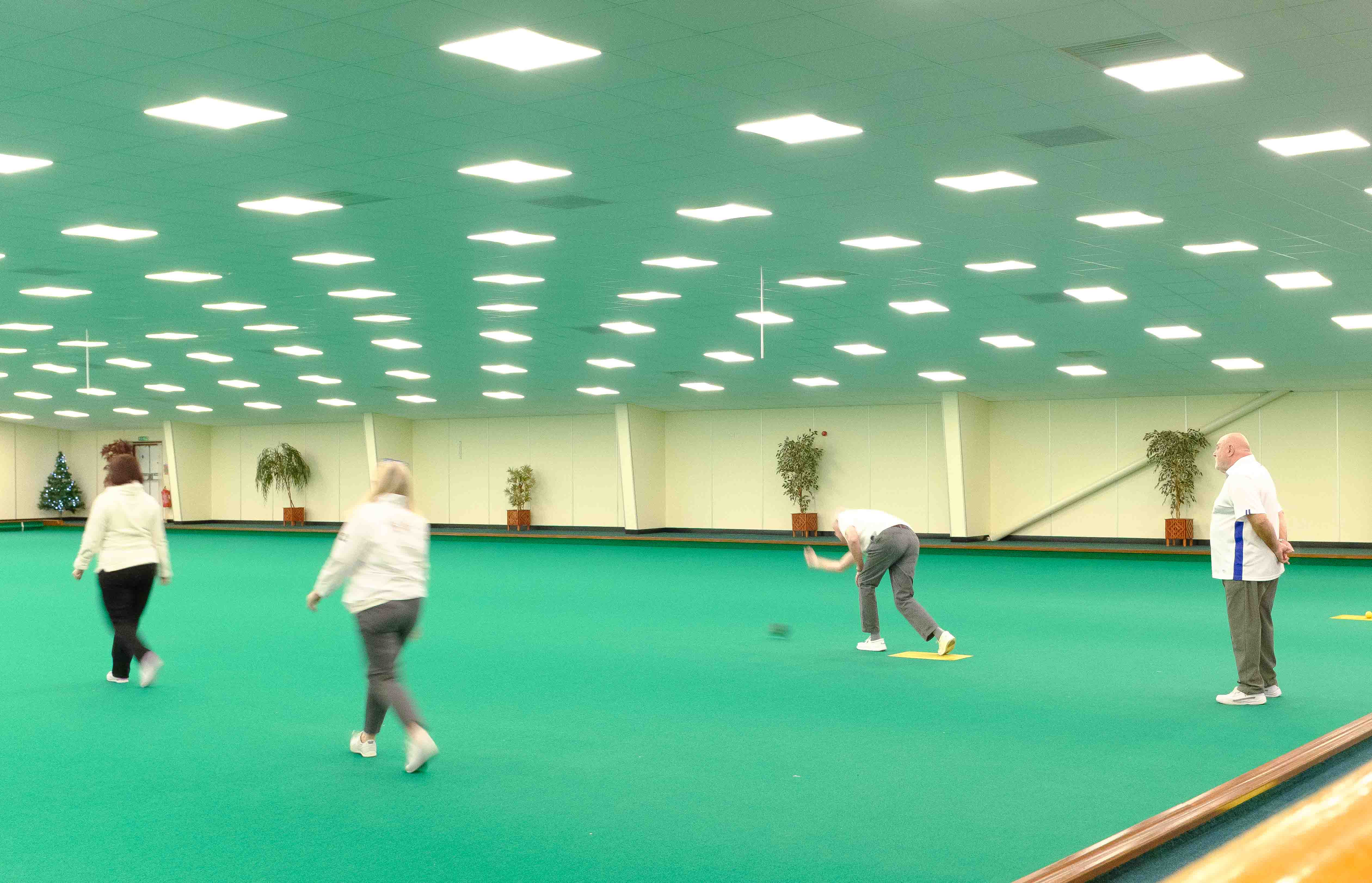 People playing indoor bowls in a brightly lit environment. Taken by Connor Redmond on the Fujifilm X100F.
