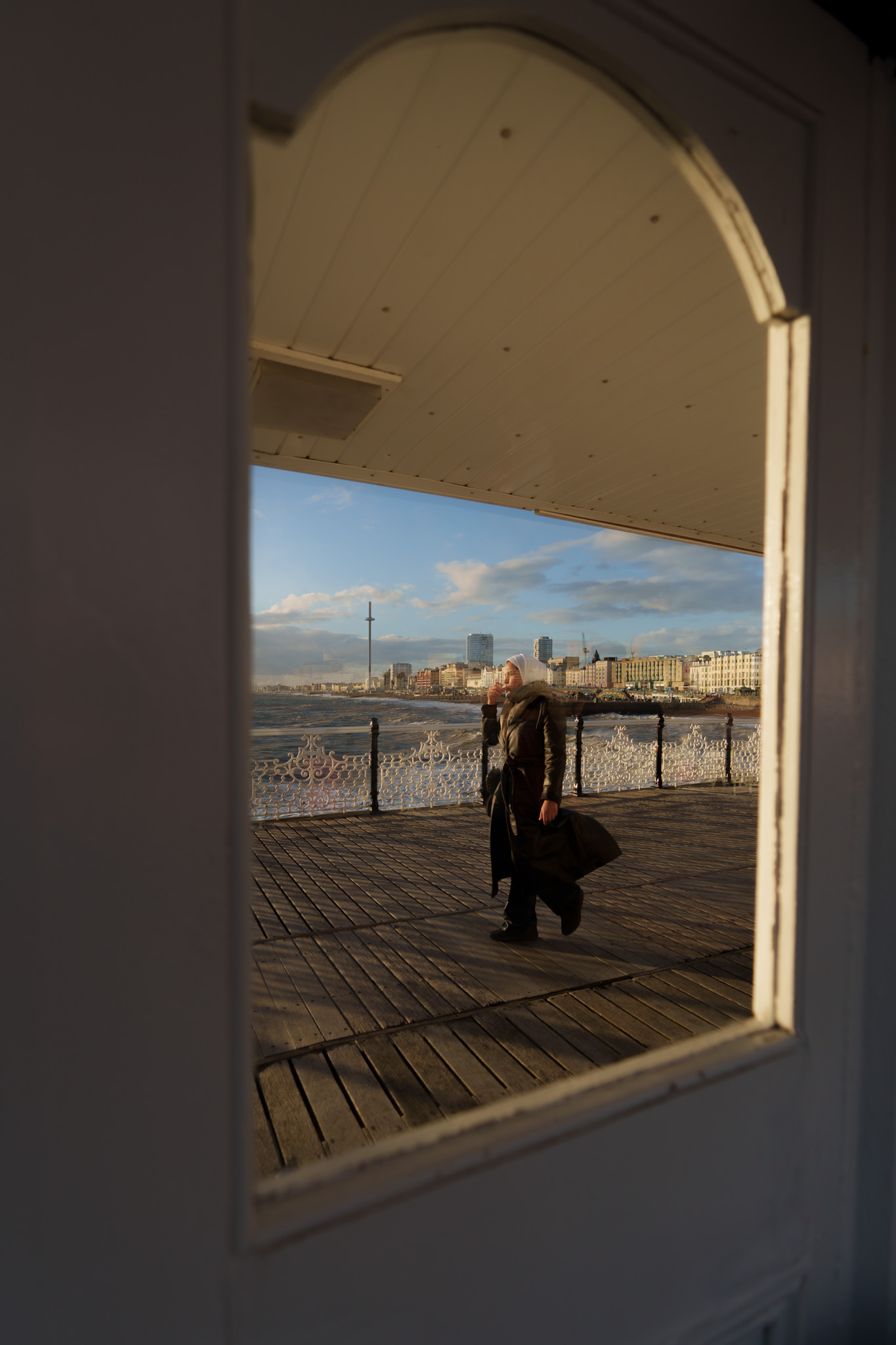 A person strolling on Brighton Pier with Brighton and the i360 in the distance. By Connor Redmond.