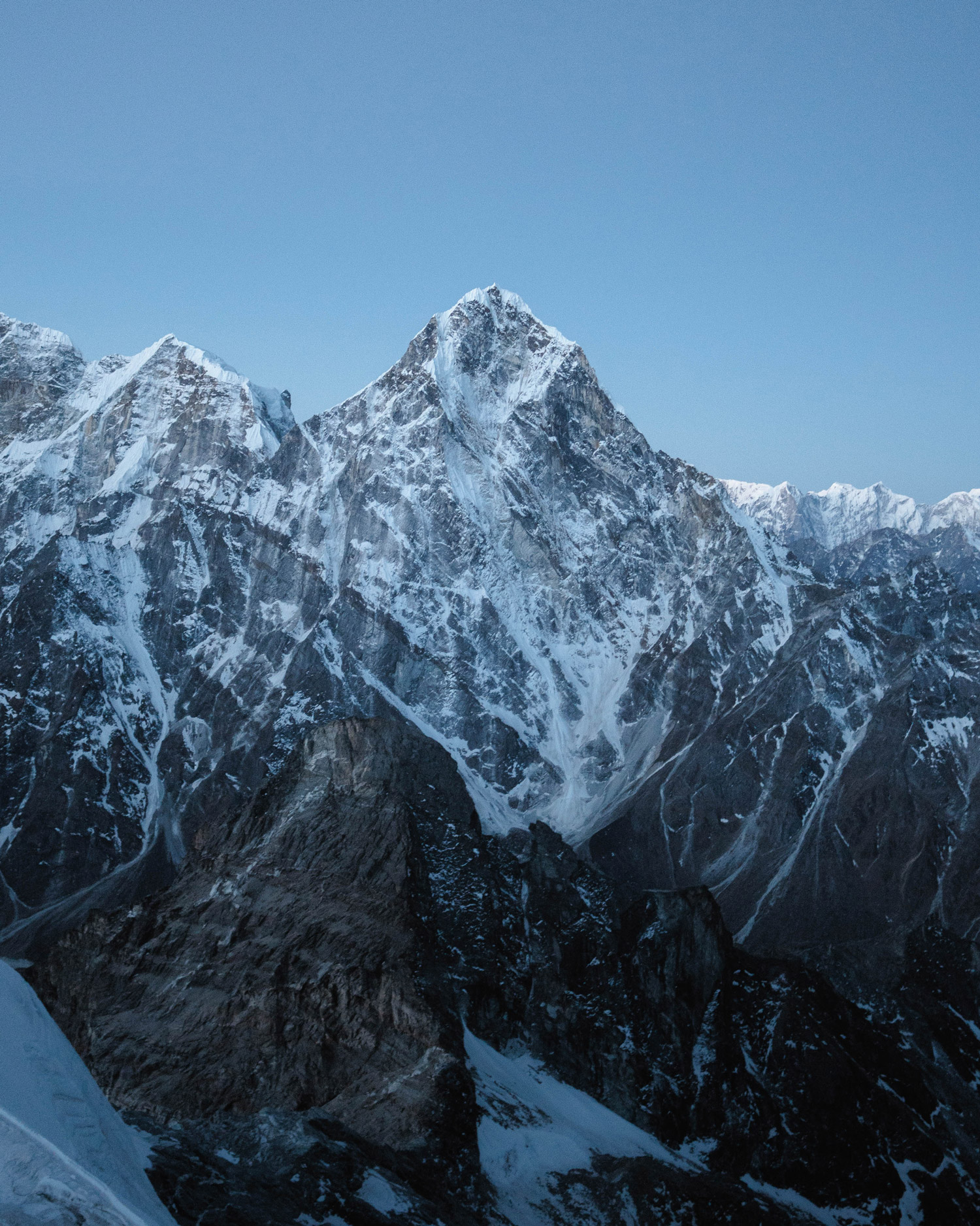 A snowy mountain range with blue skies in the background, captured by Jack Anstey with the Sony Alpha A7 IV and the Sony FE 24mm f/1.4 GM.