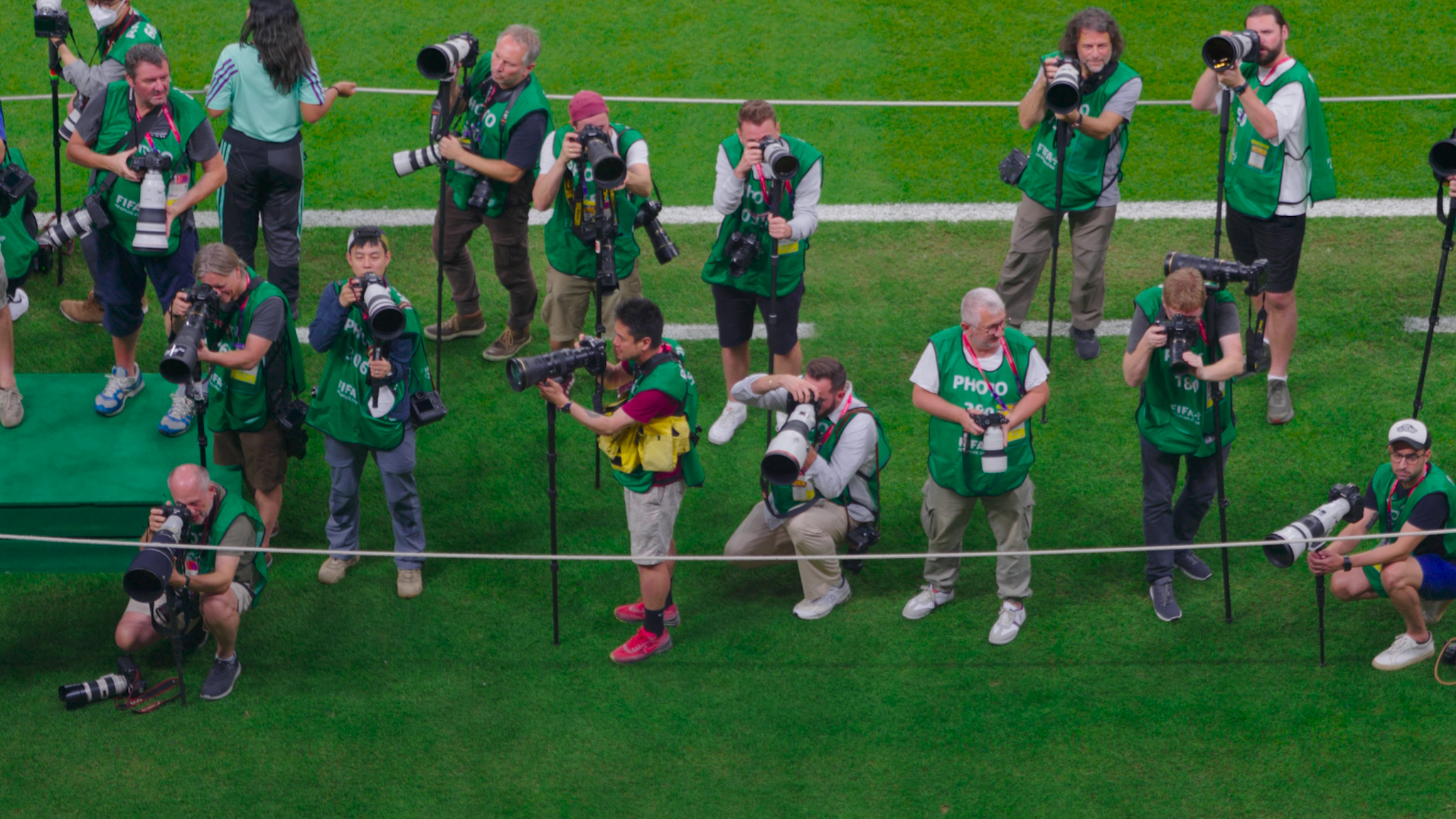 A group of sports photographers on the pitch