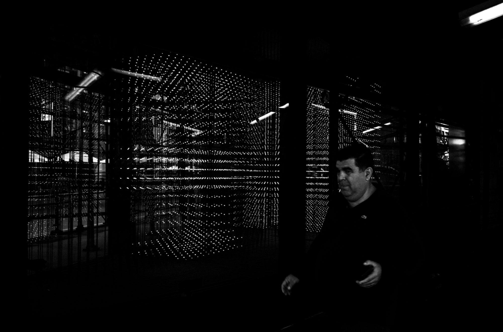 Photo en noir et blanc d’une personne passant devant un arrière-plan original