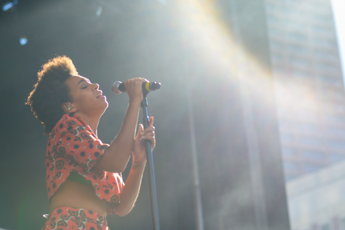 Solange on stage performing with sunlight hitting her face, photo taken by James Joiner.