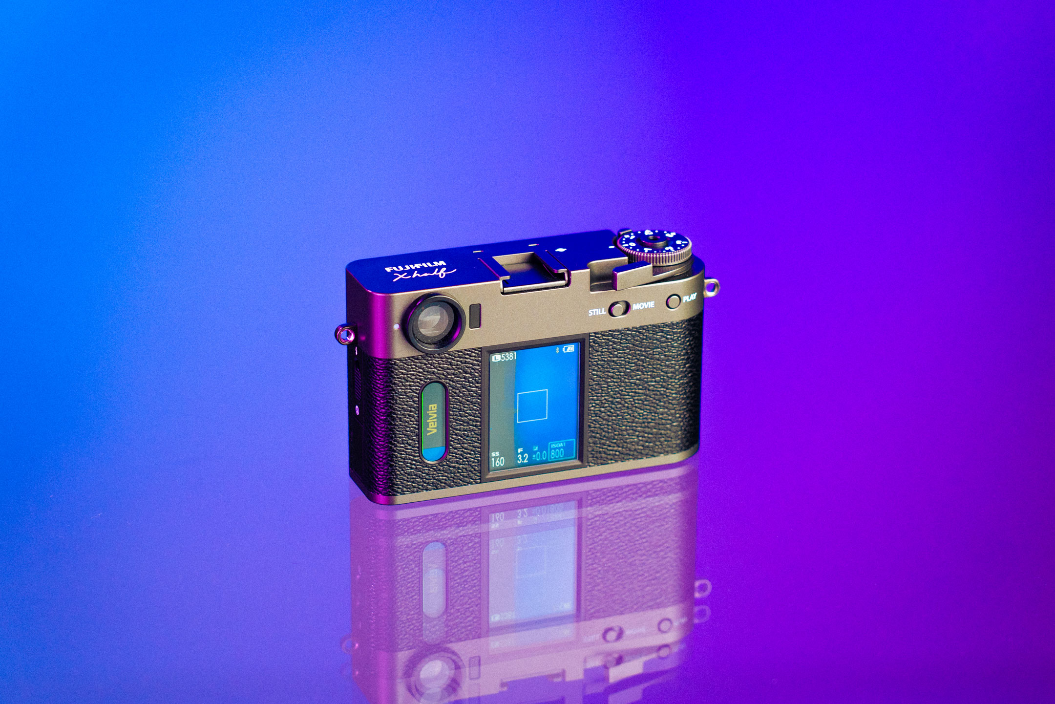 Rückseite der Fujifilm X half mit eingeschalteten Displays und ausgewählter Filtereinstellung „Velvia“.