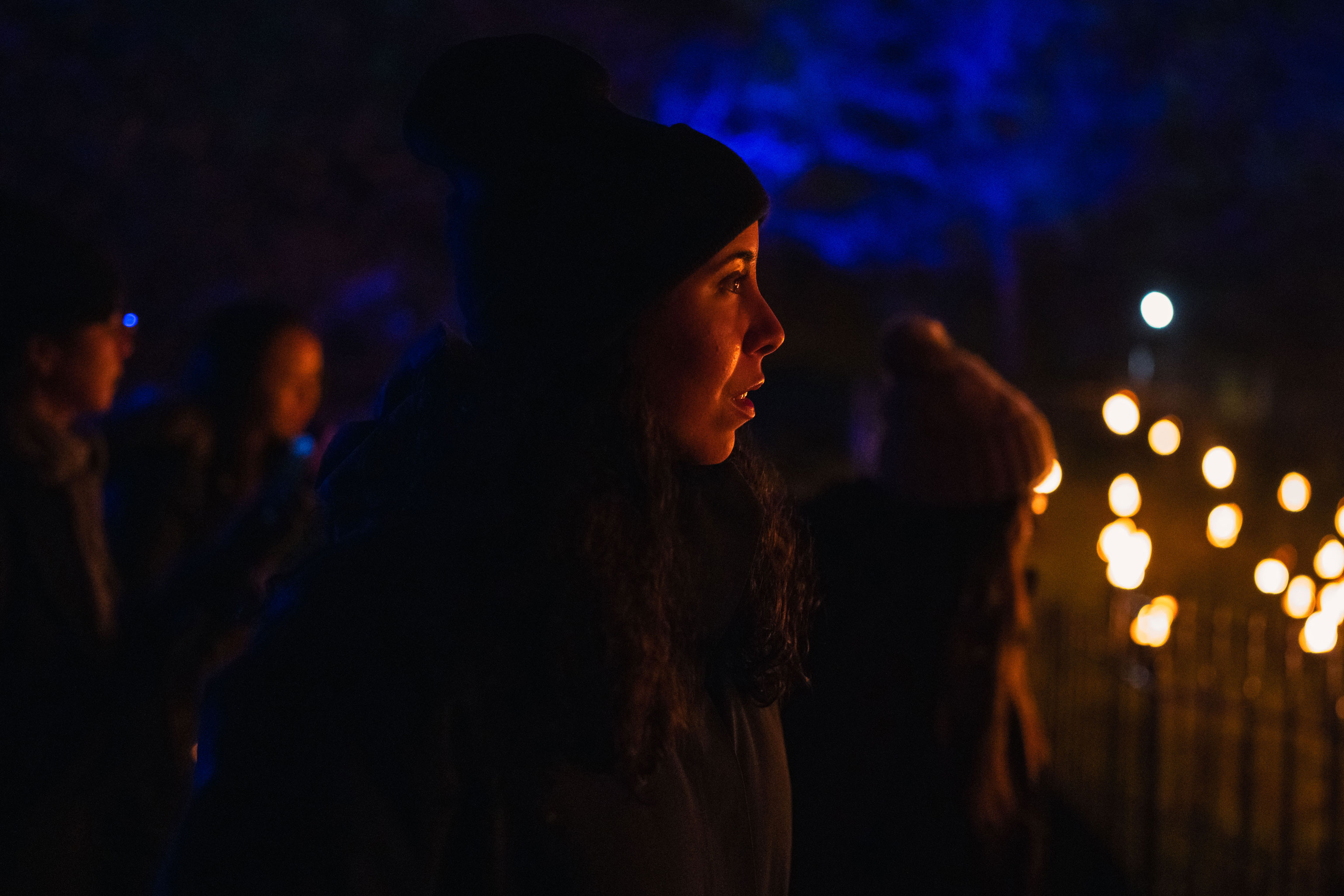Person outside in dark environment looking towards light installation in Brooklyn, NY by Manuel Pena on a Sony A1.