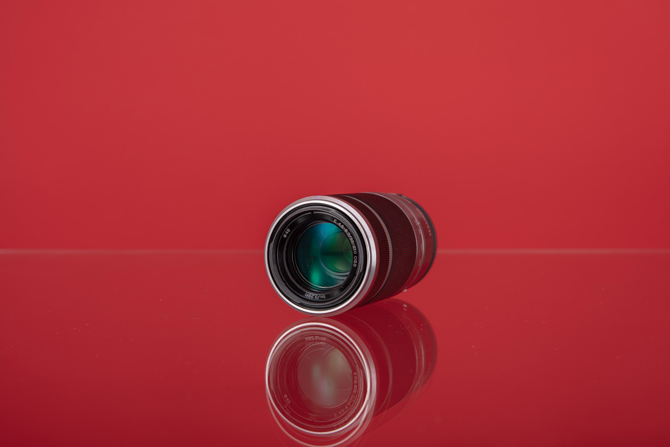 Sony E 55-210mm f/4.5-6.3 OSS met een rode achtergrond