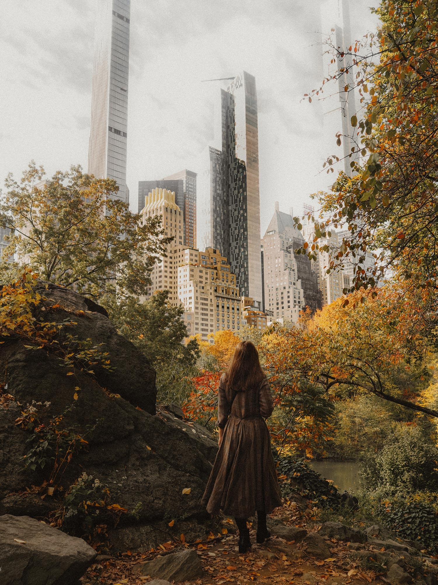 Georgina Lamrock im Central Park stehend, Bäume und Gebäude im Hintergrund. Von Georgina Lamrock mit einer Olympus PEN F aufgenommen.
