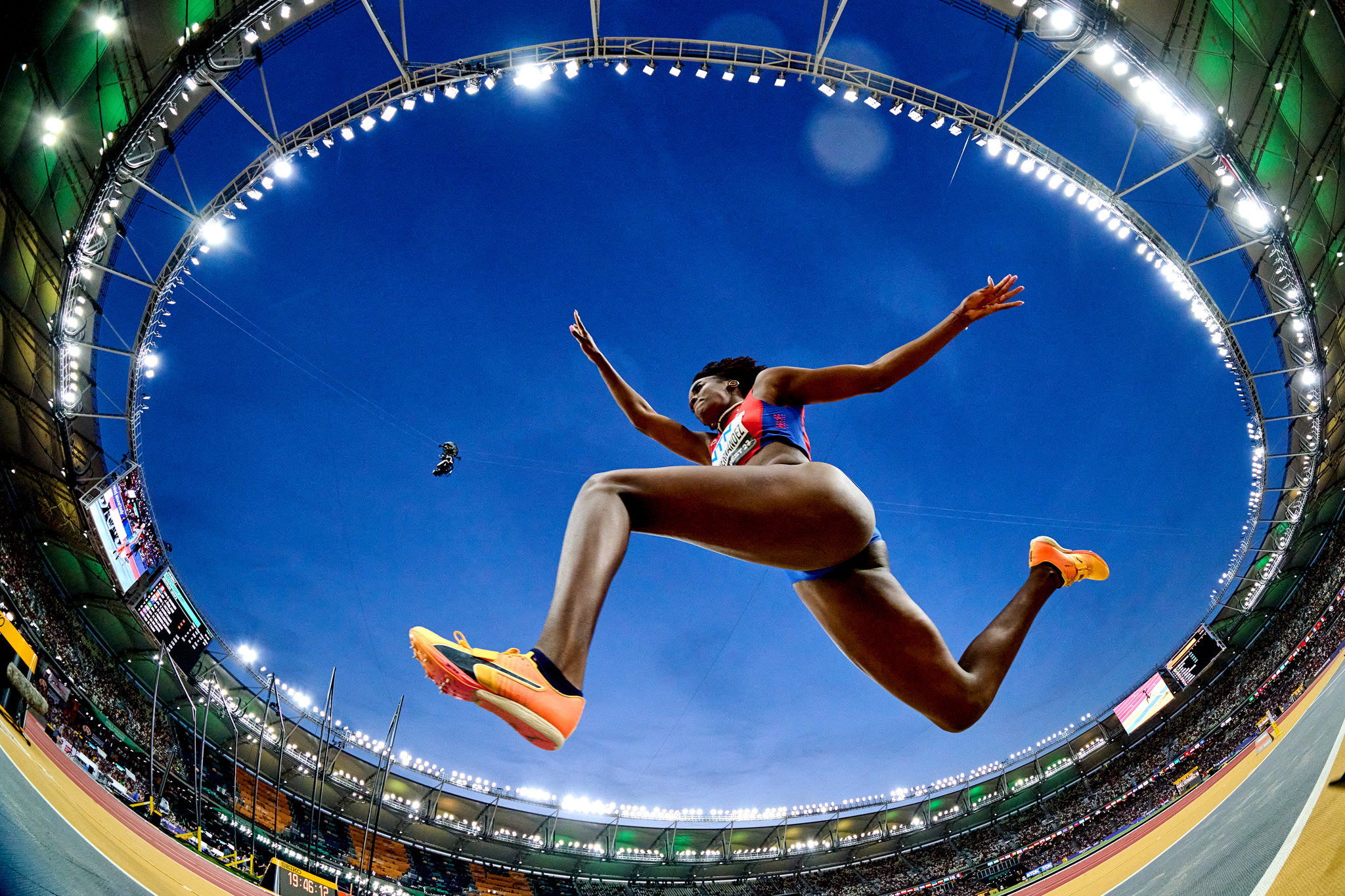 This is a super-wide fish-eye shot of an athlete jumping, with the entire stadium in the background. By Mattia Ozbot.