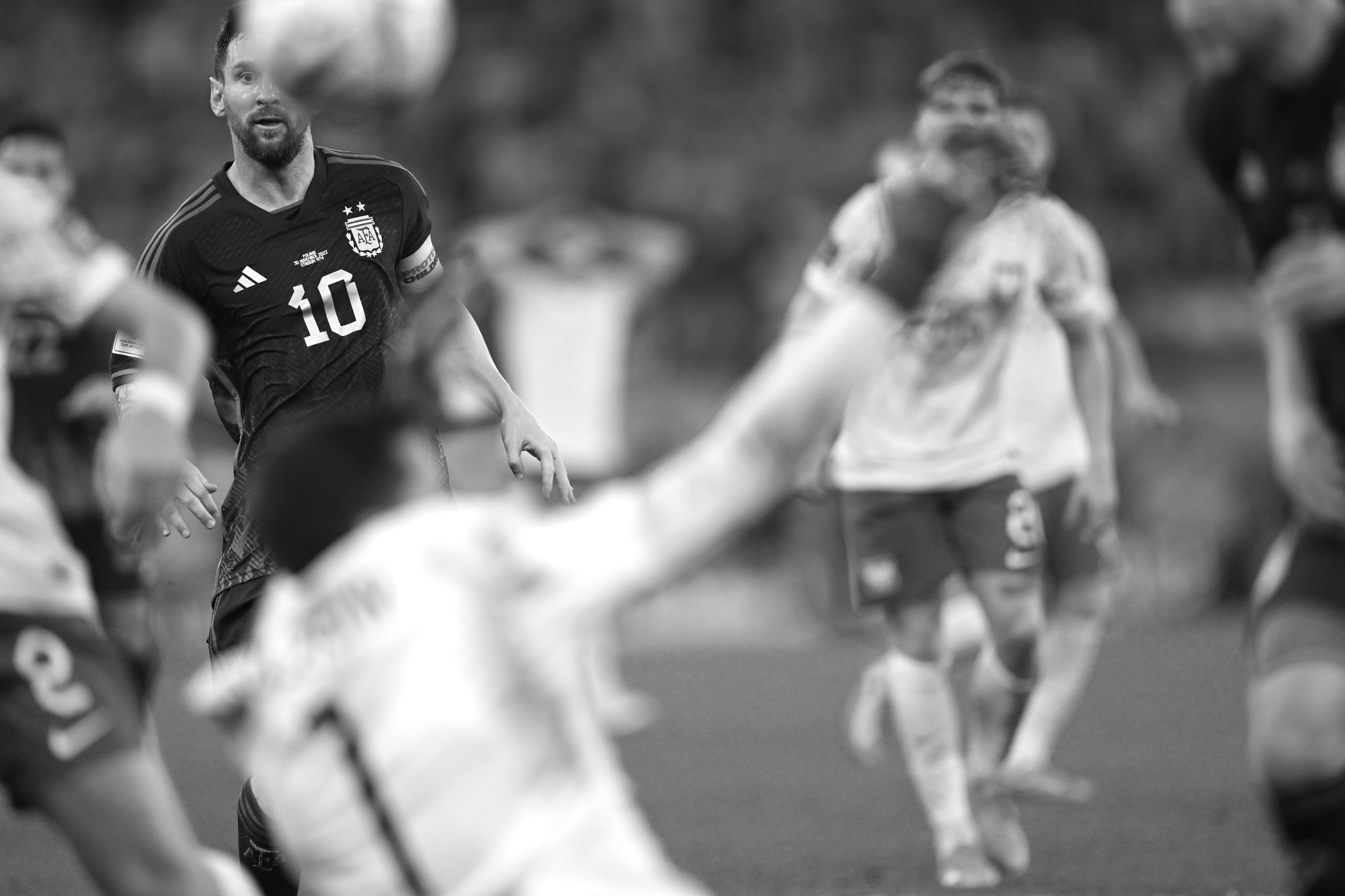 Ein Schwarz-Weiß-Foto des argentinischen Kapitäns Lionel Messi, der während des 2:0-Sieges seiner Mannschaft gegen Polen bei der Fußball-Weltmeisterschaft 2022 den Ball im Auge behält, der sein Gesicht teilweise verdeckt, aufgenommen von Ryu Voelkel mit einer Nikon Z9.