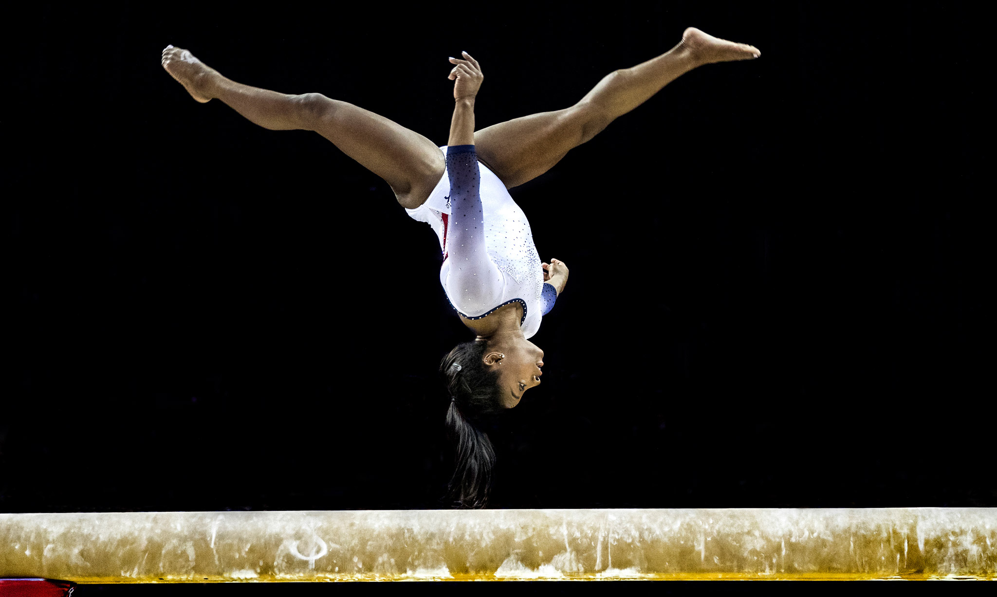 A gymnast mid-flip on the bench