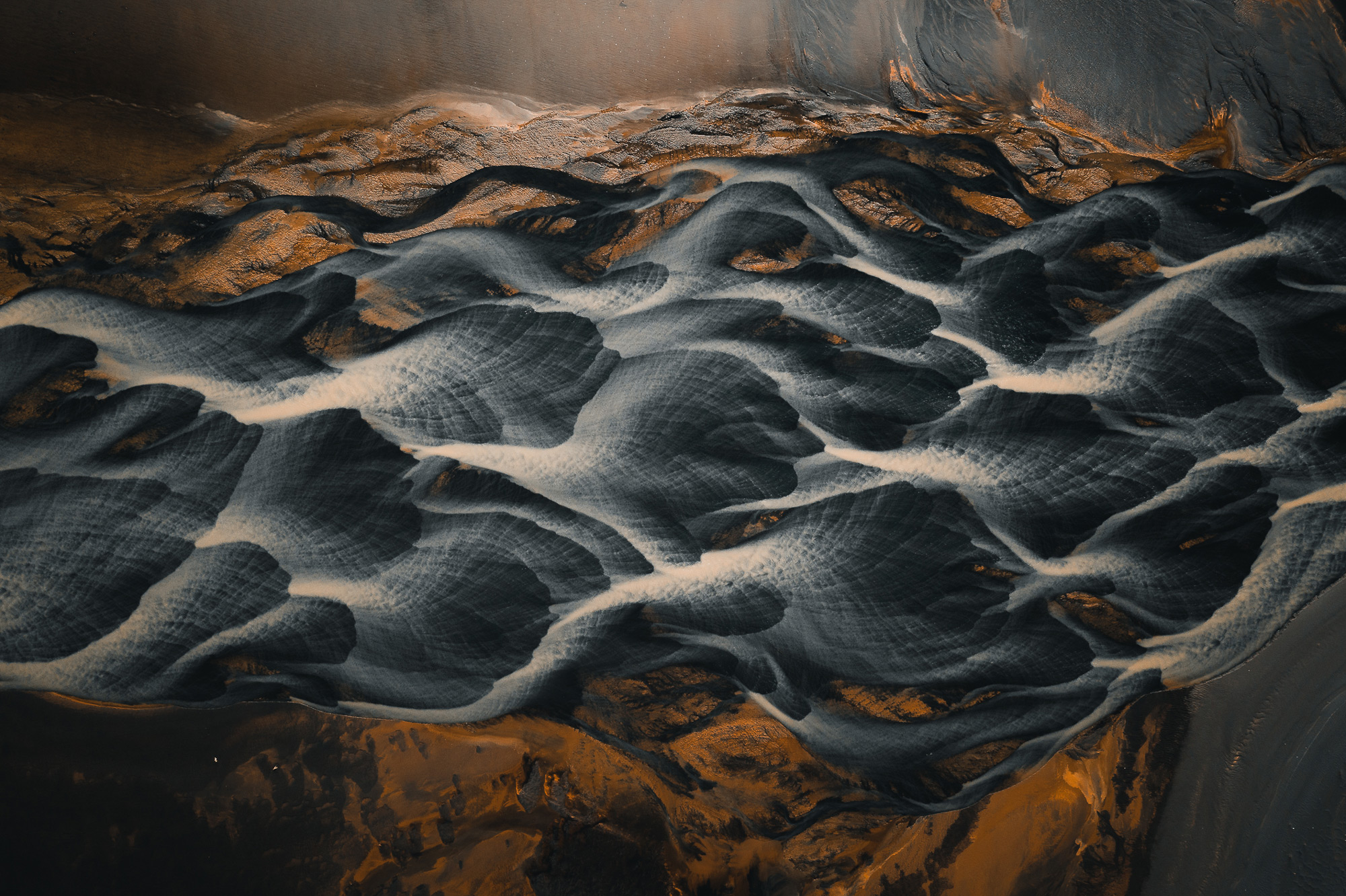 A higher-up aerial drone abstract painting-like photo of blue-and-white rivers running through a valley in Iceland, shot by Paul Watson with a DJI Mavic 2 Pro