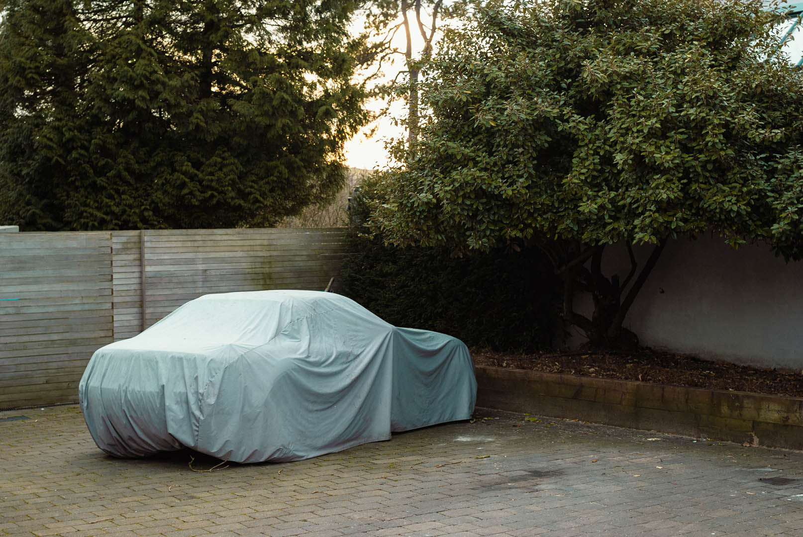 Parked car with a cover over it by Jakub Golis

