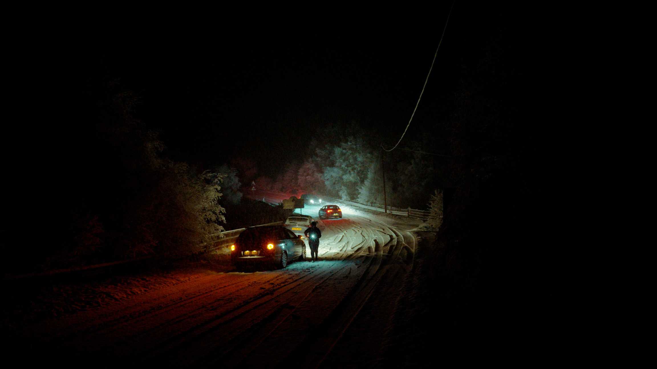 Cars on a snowy road at night