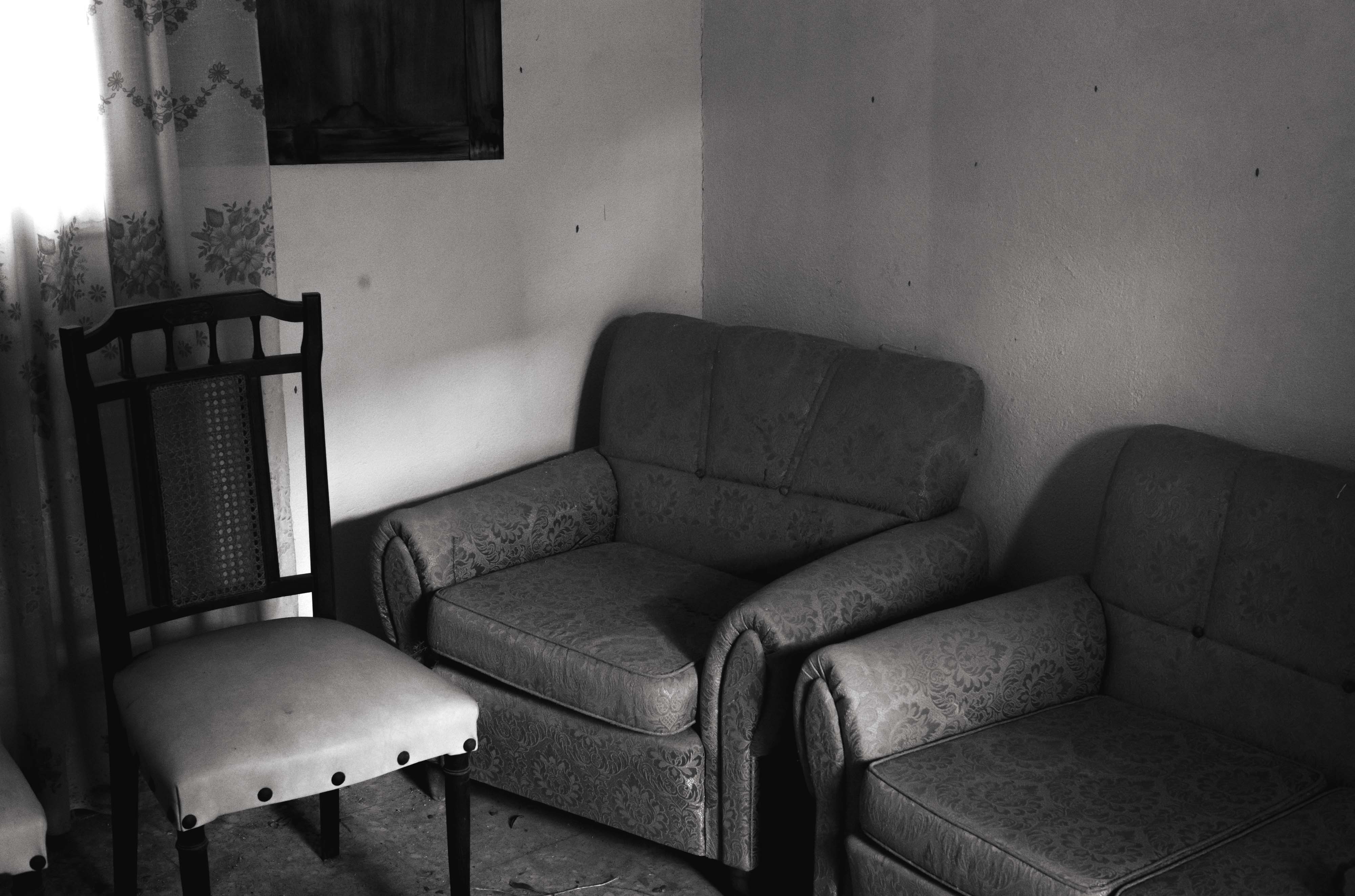 A black-and-white photo of a room with a chair and two armchairs shot with a Leica M10 Monochrom