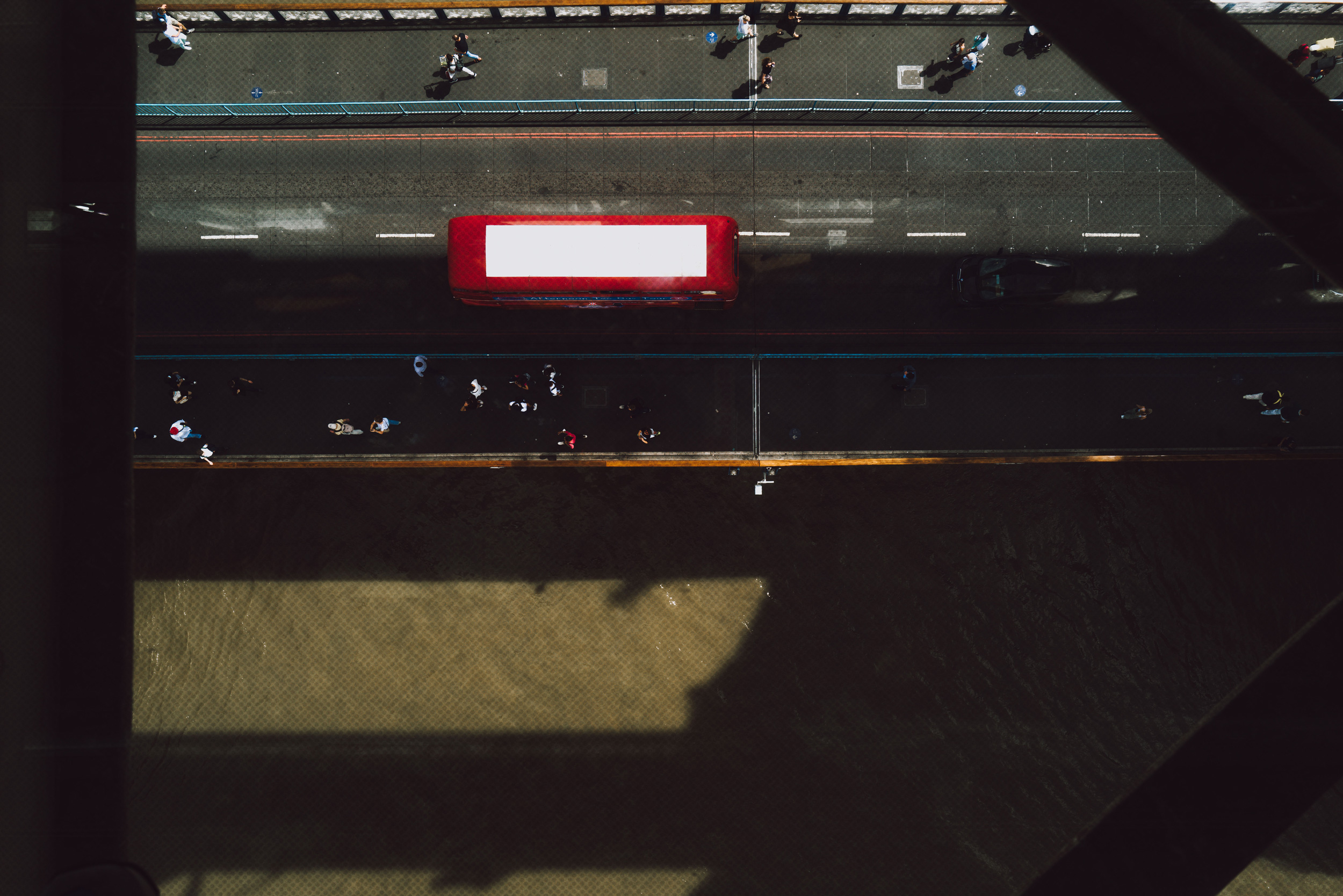 Ein Foto aus der Vogelperspektive eines roten Londoner Busses, der über die Tower Bridge fährt, während die Themse darunter hindurchfließt, aufgenommen mit der Leica Q2.
