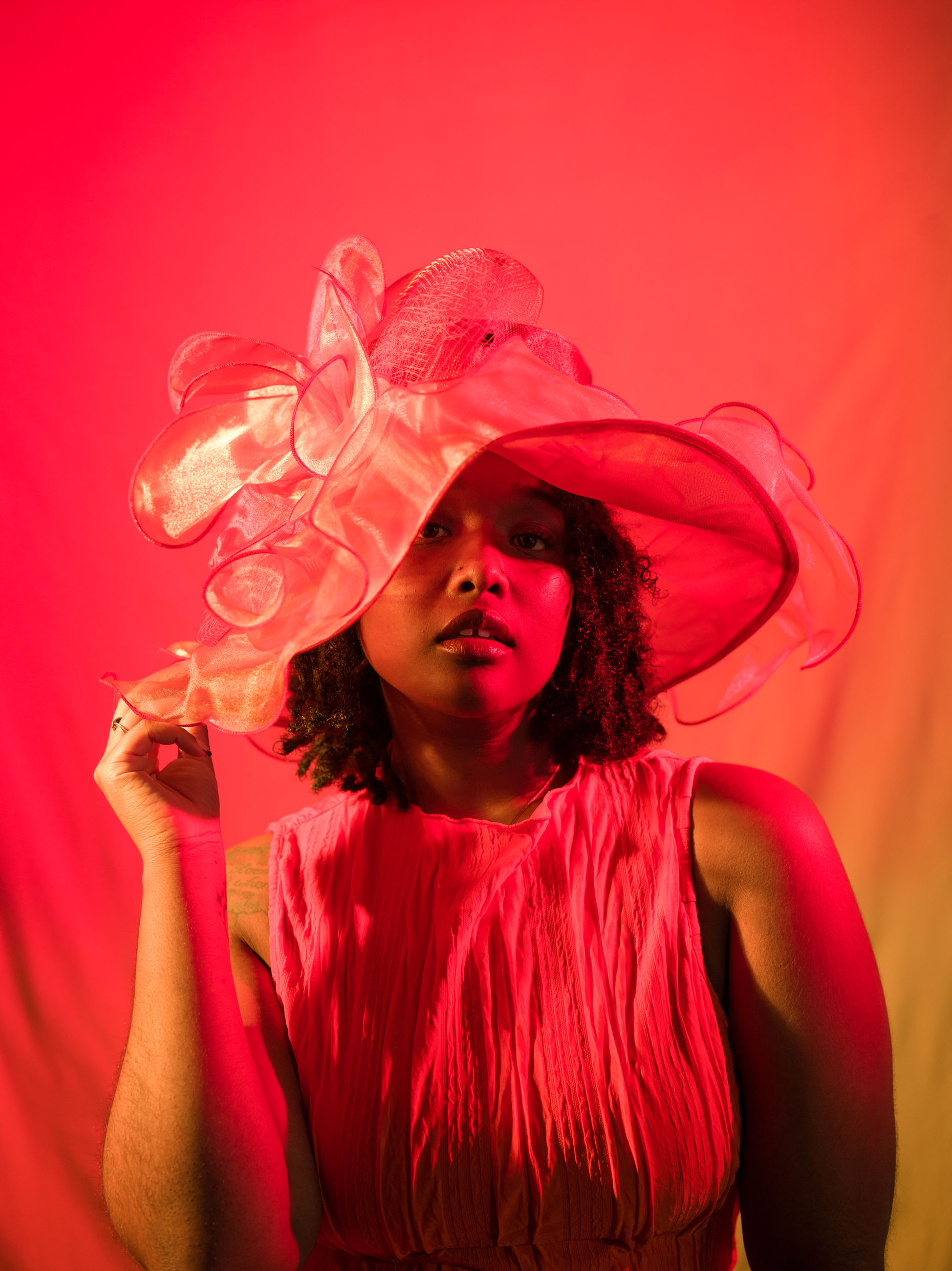 Portrait of a person wearing a red hat with red light. Taken by Kaylah Sambo on a Hasselblad X1D-50c.