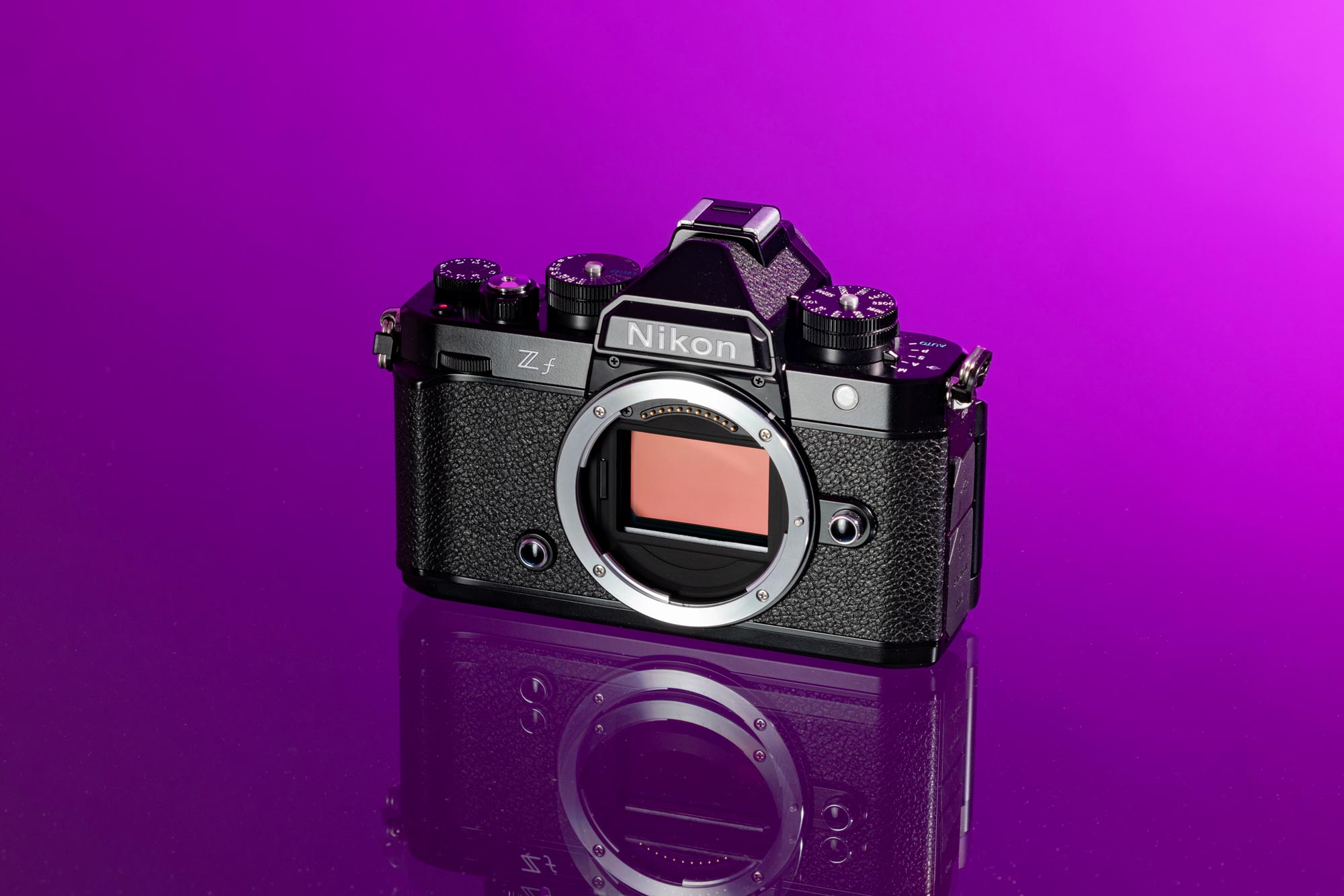 Used Nikon Zf body without a lens on a reflective purple background