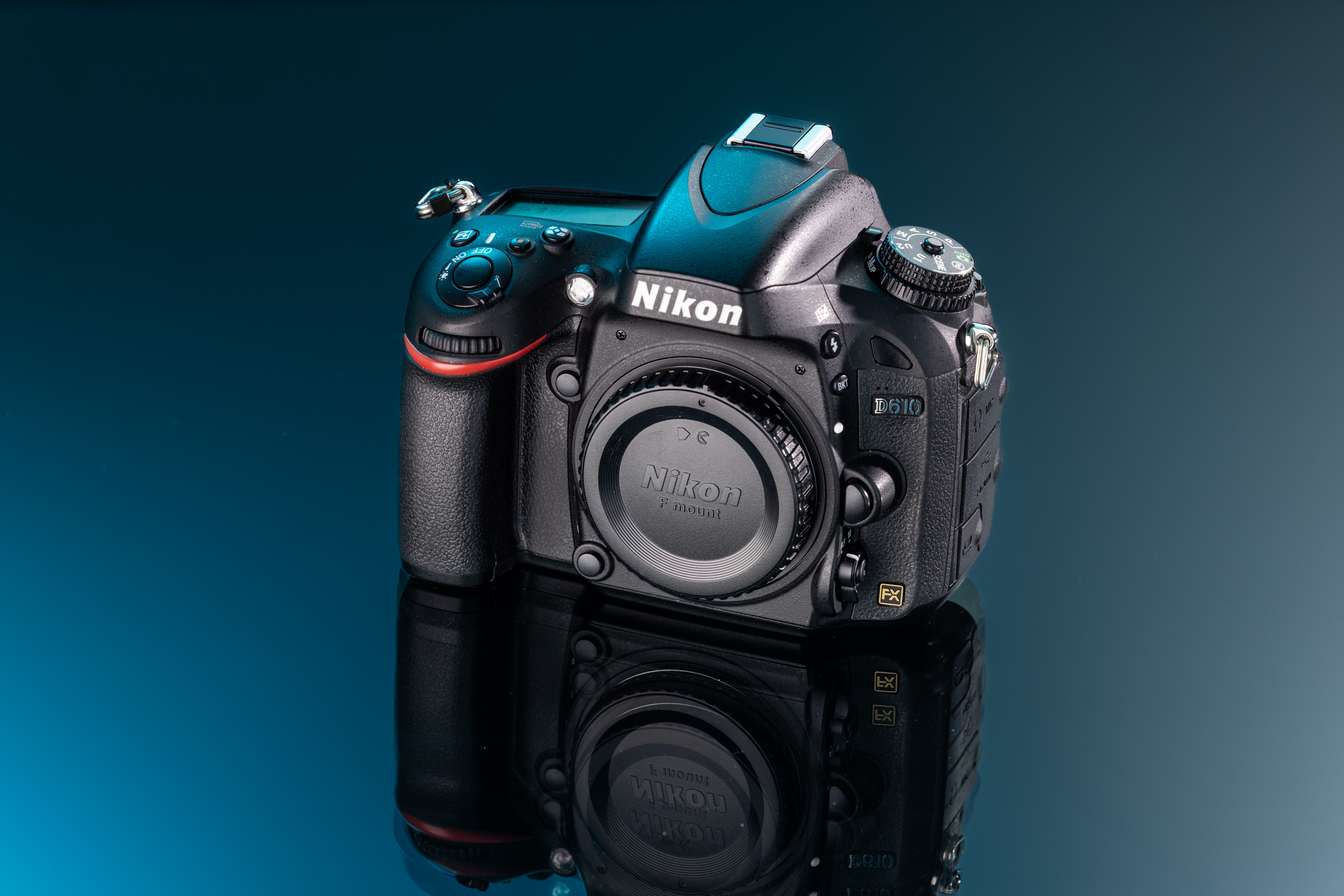 Tweedehands Nikon D610 op een blauwe en zwarte achtergrond