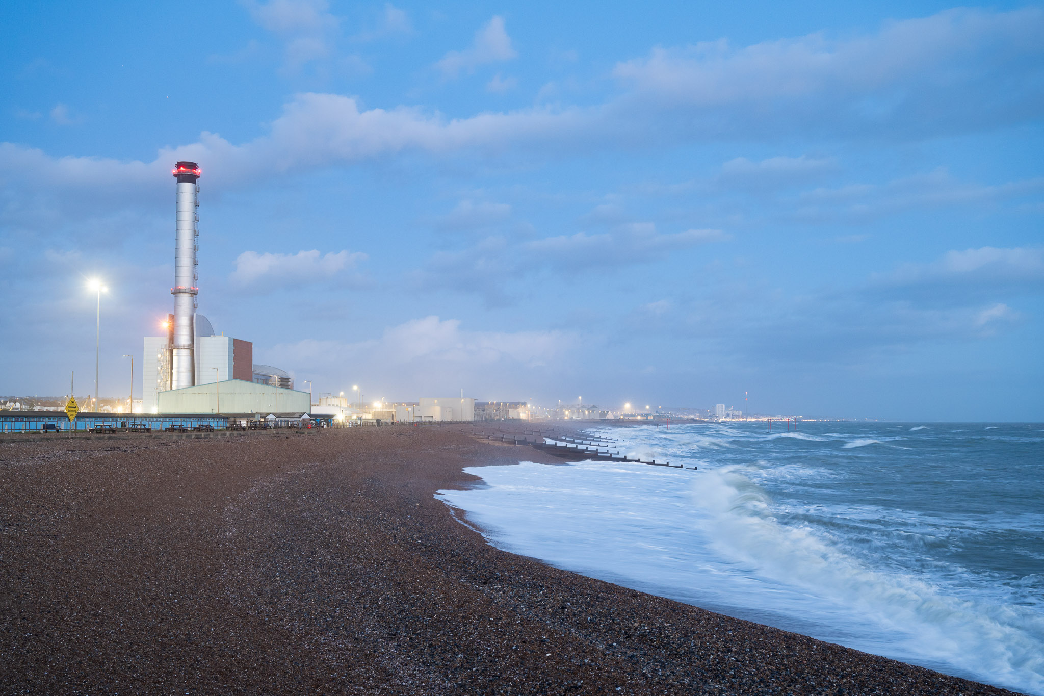 Coastal power station and chimney at blue hour with waves rolling in, photographed with the Nikon Zf by Amy Moore. 
