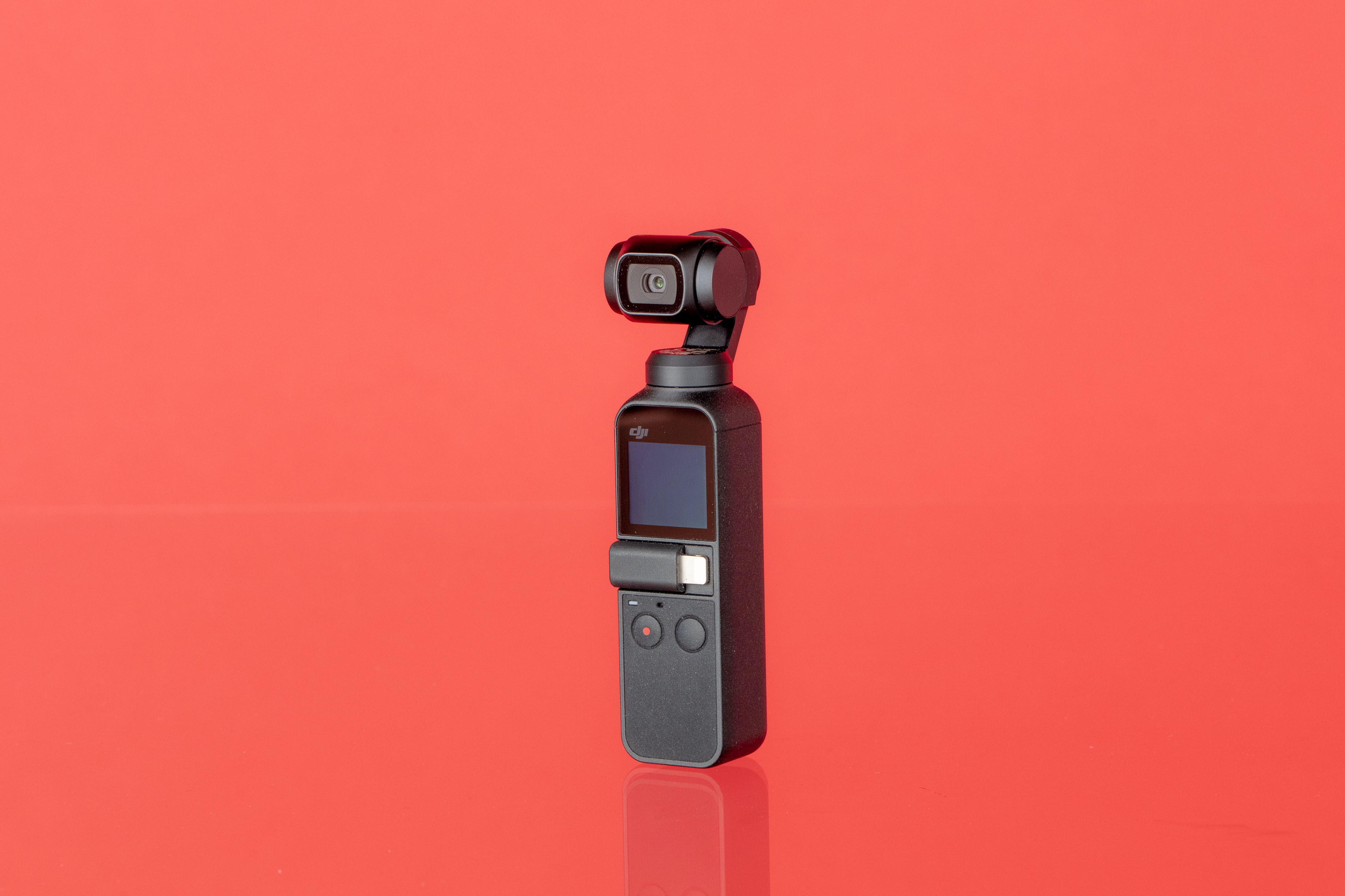 DJI Osmo Pocket camera shot on a red background. 