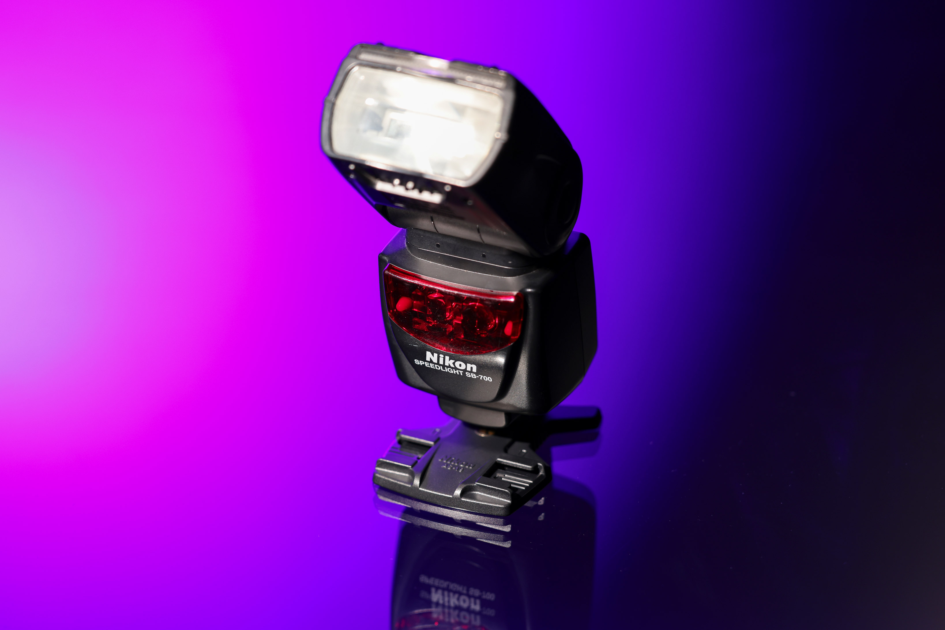 Nikon SB-700 Speedlight against a purple and black background.