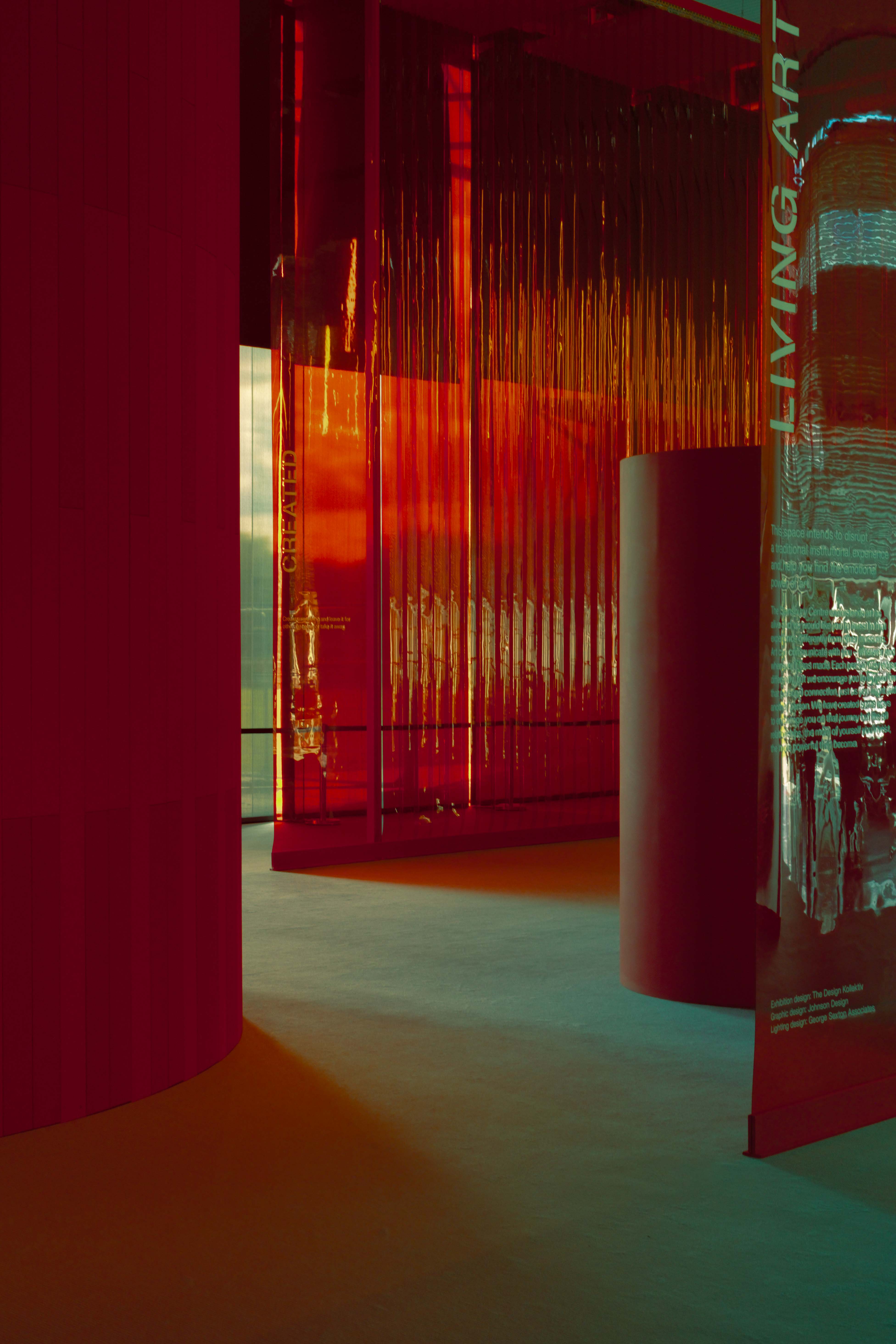 A room with red walls with green light beaming in. By Connor Redmond.
