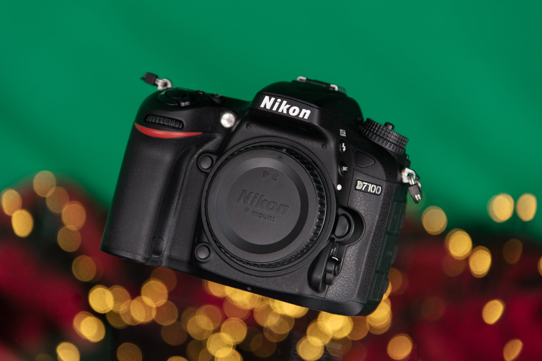 Nikon D7100 vor einem roten und grünen Hintergrund mit gelben Bokeh-Lichtern
