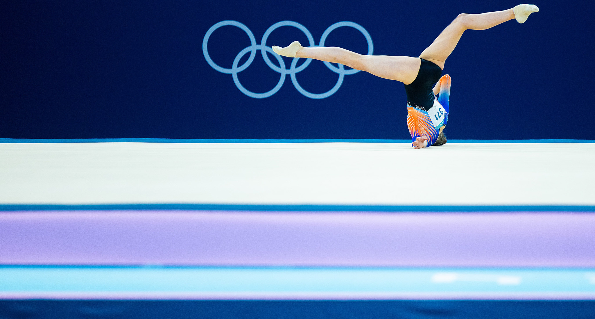 A gymnast with their head on the floor mid-dance at the 2024 Olympics. By Iris van den Broek.