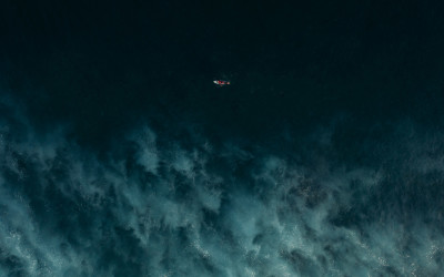 Ein Kajak, das auf einem dunklen Meer treibt, aus der Vogelperspektive, aufgenommen mit einer DJI Mavic 2 Pro von Reisefotograf Harry Pope.