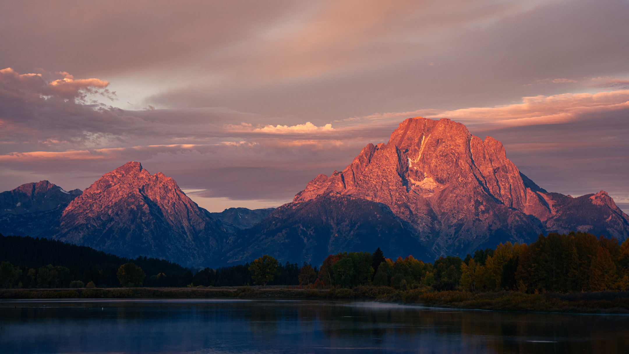 Wyoming mountain at dusk with water in the background