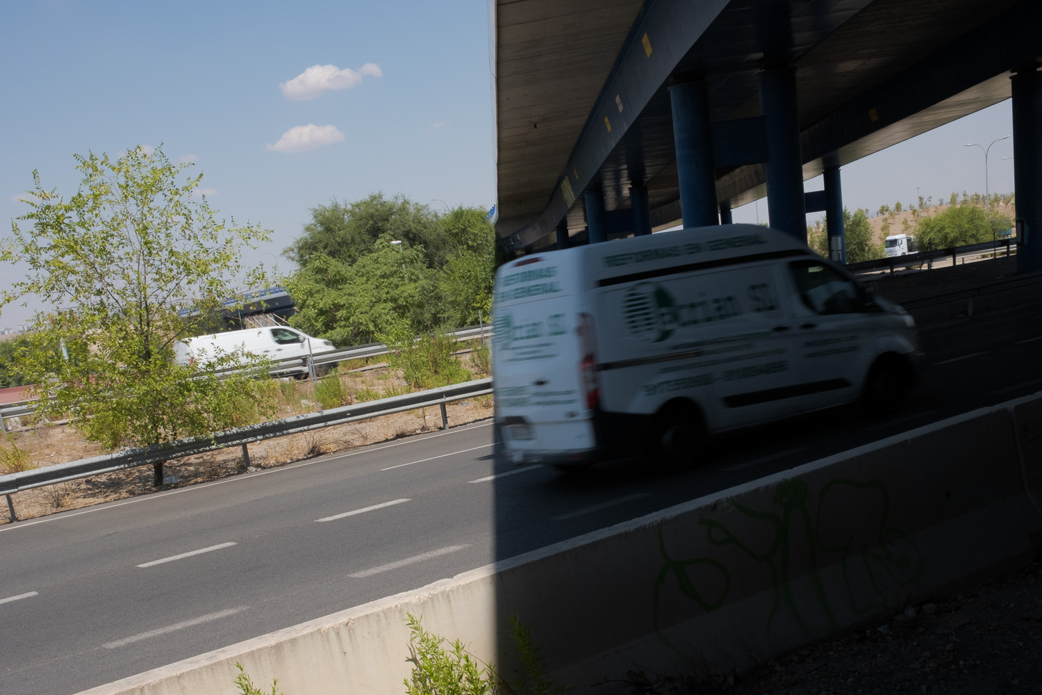 Ein Lieferwagen auf der Autobahn, der mit hoher Geschwindigkeit unter einer Brücke hindurchfährt