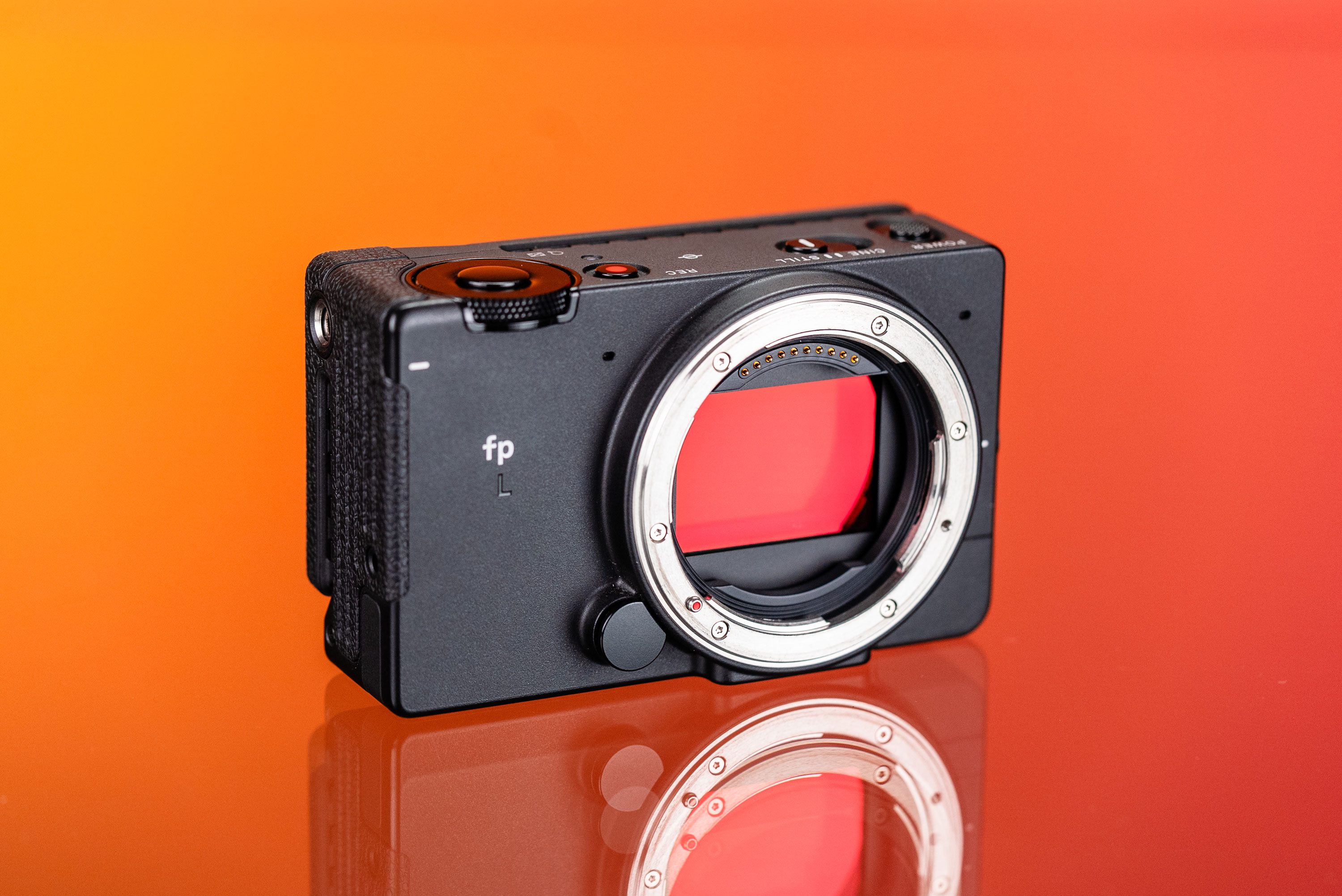 Gebrauchte Sigma fp L auf orange-rotem Hintergrund